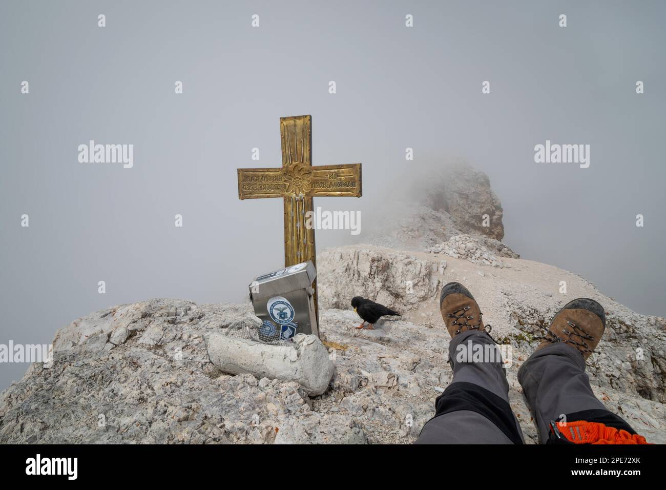 Vue cachée par les nuages du sommet de Cima di Mezzo (3154 m) . Le touriste se repose avec l'oiseau qui l'accompagne., Dolomites, Italie, Europe Banque D'Images
