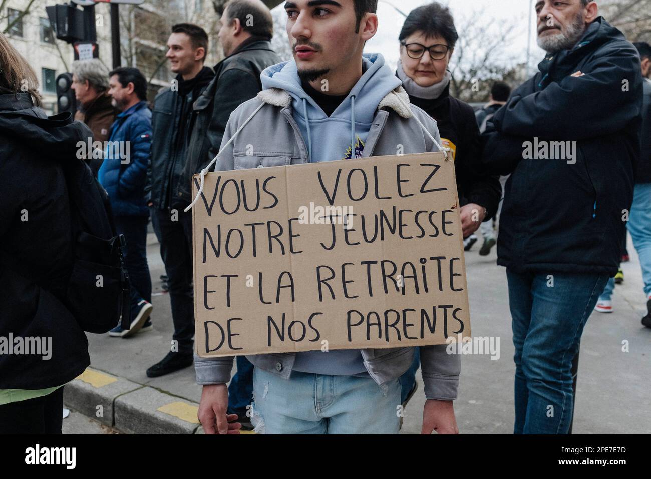 Paris, France. 15th mars 2023. Jan Schmidt-Whitley/le Pictorium - manifestation contre la réforme des retraites à Paris - 15/3/2023 - France/Paris/Paris - Un démonstrateur porte un signe disant: Vous volent les pensions de nos jeunes et de nos parents. Des dizaines de milliers de personnes se sont rassemblées à Paris à l'appel de l'inter-Union pour manifester leur opposition à la réforme menée par le gouvernement d'Elisabeth borne. Des affrontements occasionnels ont éclaté tout au long de la journée. Credit: LE PICTORIUM / Alamy Live News Banque D'Images