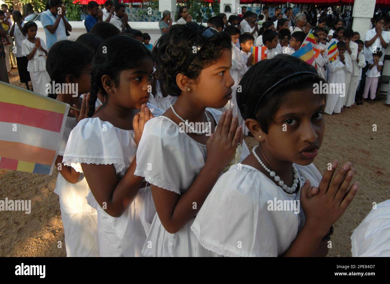Buddhist girls pray during traditional New Year rituals in a temple in Colombo, Sri Lanka, Saturday, April 16, 2005. Sri Lankans are celebrating a week of New Year festivities during which they forgo work and follow traditions and rituals that include taking oil baths at an auspicious time.(AP Photo/Eranga Jayawardena) Banque D'Images