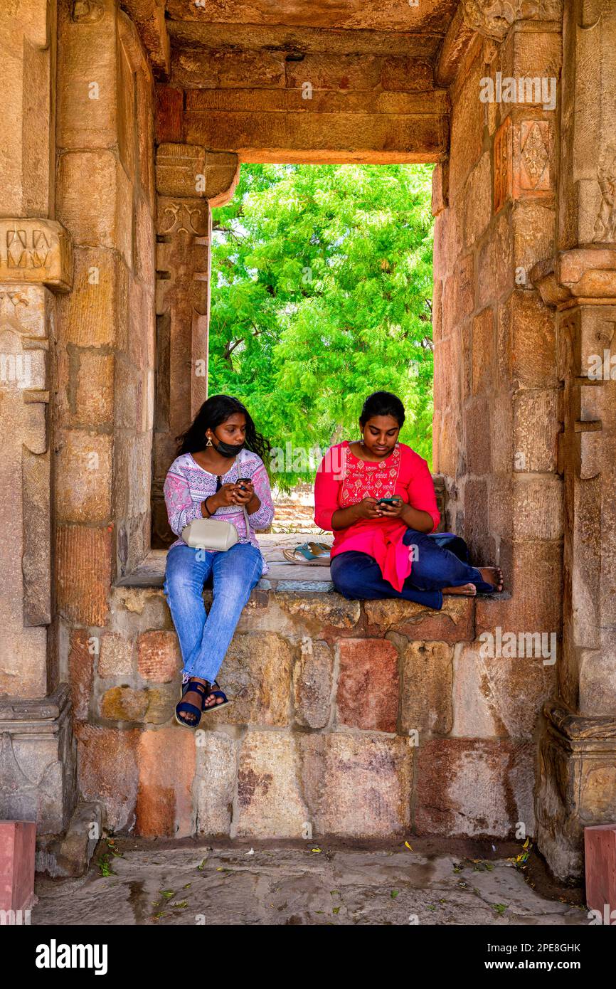 Médias sociaux au milieu des colonnes du cloître historique de la mosquée Quwwat ul-Islam au complexe Qutub Minar, Delhi, Inde Banque D'Images