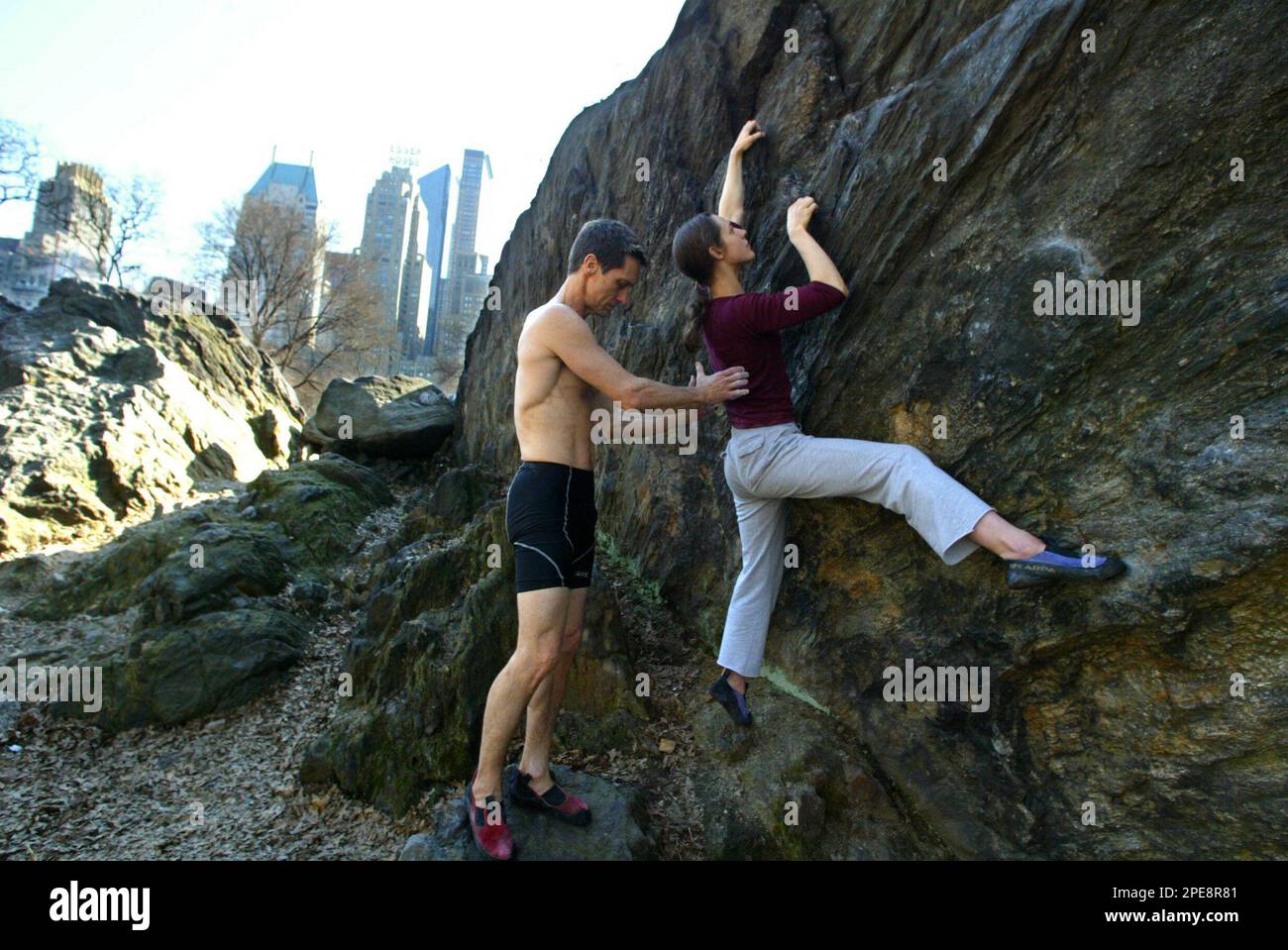Christopher Lawrence, left, of Manhattan, N.Y., spots Sarah Plumer, of Brooklyn, N.Y., while she climbs Rat Rock in New York's Central Park, Wednesday, April 6, 2005. Bouldering, with its low overhead, easy access, sociability and limitless challenges, is the big trend in their sport, climbers say. (AP Photo/Mary Altaffer) Banque D'Images