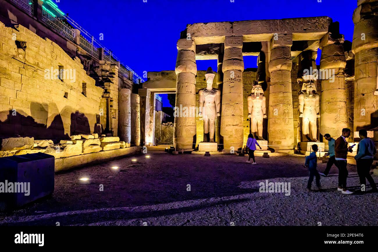 Statues illuminées du roi Ramsès II dans la première cour du temple de Louxor. Banque D'Images