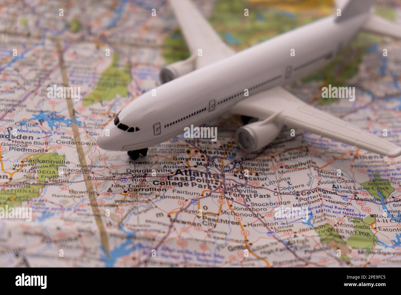 Gros plan d'un avion de tourisme miniature sur une carte colorée mettant l'accent sur Atlanta Georgia grâce à une mise au point sélective, flou d'arrière-plan Banque D'Images