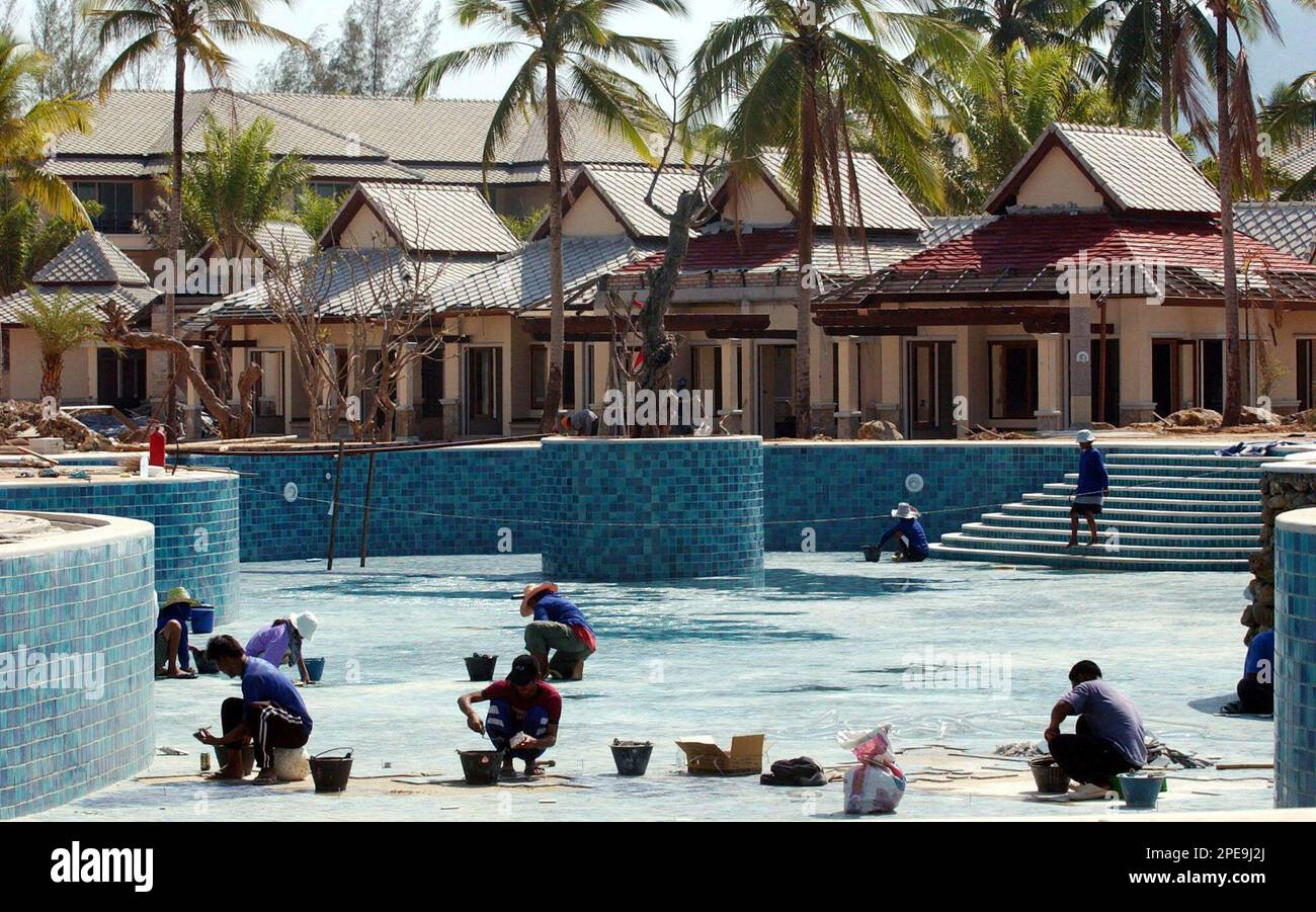 Workers lay the tiles on the floor of a swimming pool of Le Meridien Khao Lak hotel, damaged by the Dec. 26 tsunami at Khao Lak beach in Takuapa district of Pang-nga province, southern Thailand Friday, March 11, 2005. Le Meridien, one of the hotels in the Khao Lak resort area, popular with western tourists, is on its rebuilding and renovating that expect to reopen by October this year, according to a hotel developer. (AP Photo/Apichart Weerawong) Banque D'Images