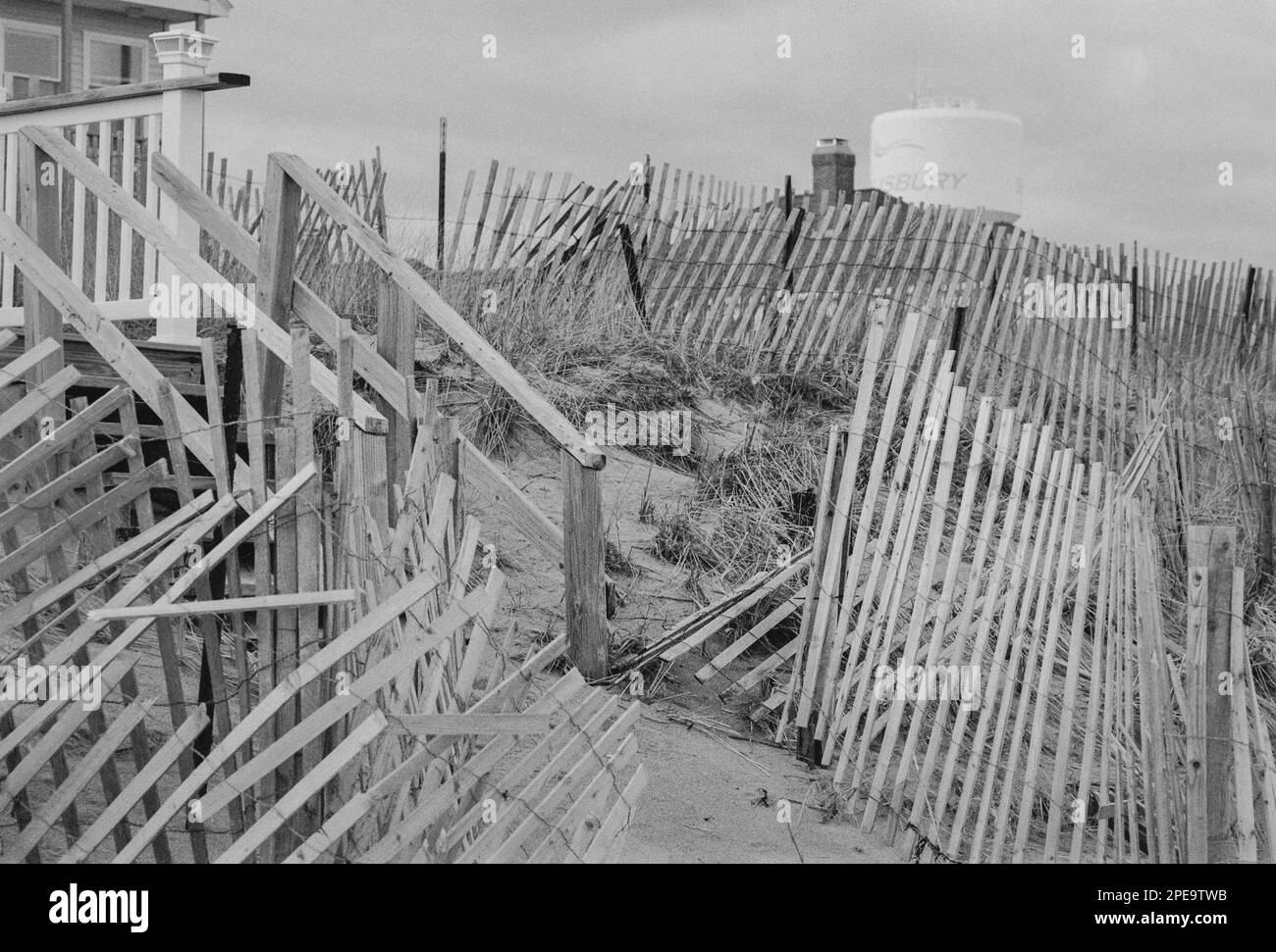 Des clôtures de tempête en bois et en fil de fer sillonent les maisons d'été au bord de la plage de Salisbury Beach, Massachusetts. L'image a été capturée en noir analogique Banque D'Images