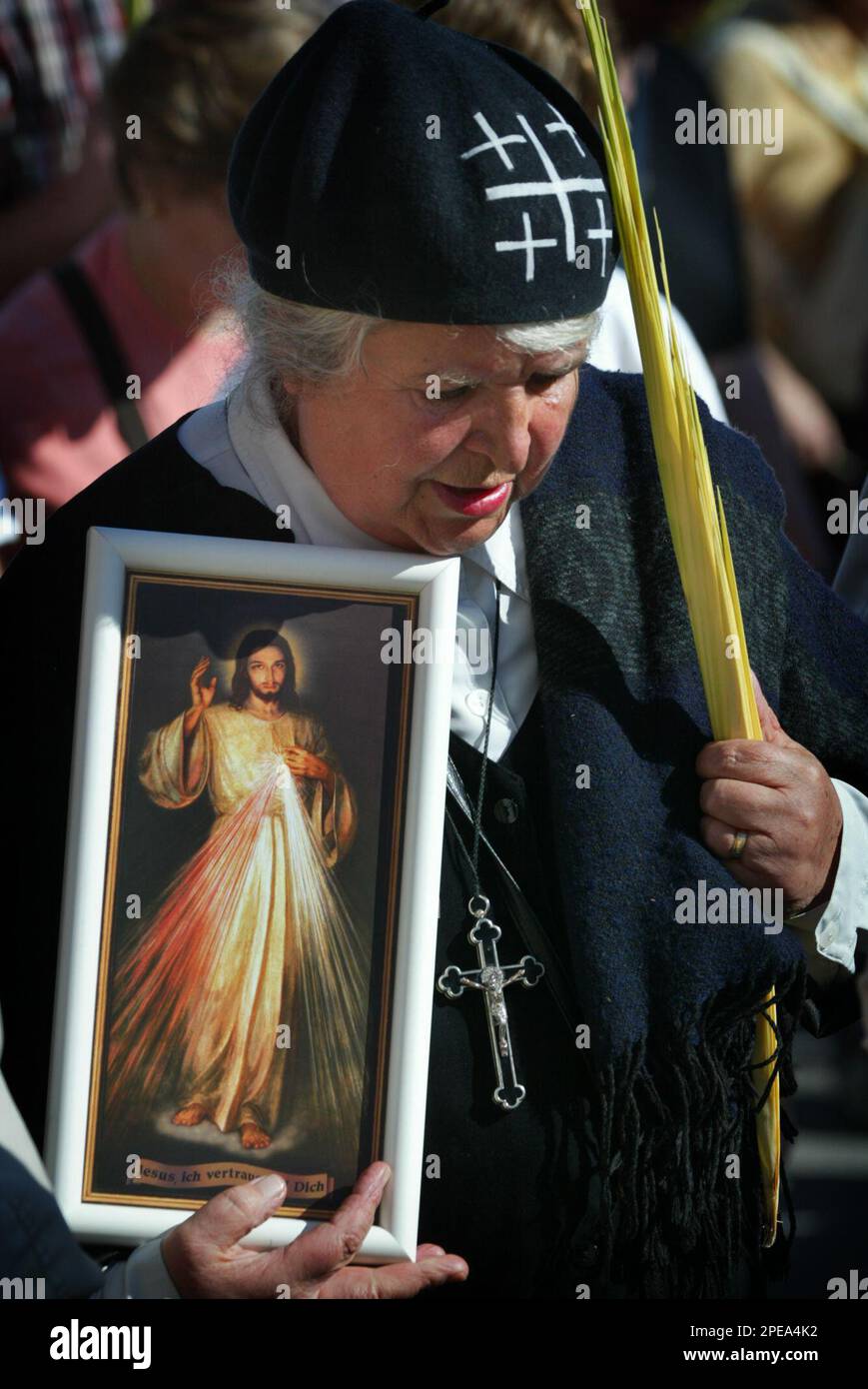 A pilgrim carries a palm leave and a framed image of Jesus during the traditional Palm Sunday procession in Jerusalem's Mount of Olives, Sunday March 20, 2005. Palm Sunday, which begins the Christian church's most solemn period, marks for Christians Jesus Christ's entrance into Jerusalem, when his followers laid palm branches in his path, before his crucifixion. (AP Photo/Enric Marti) Banque D'Images