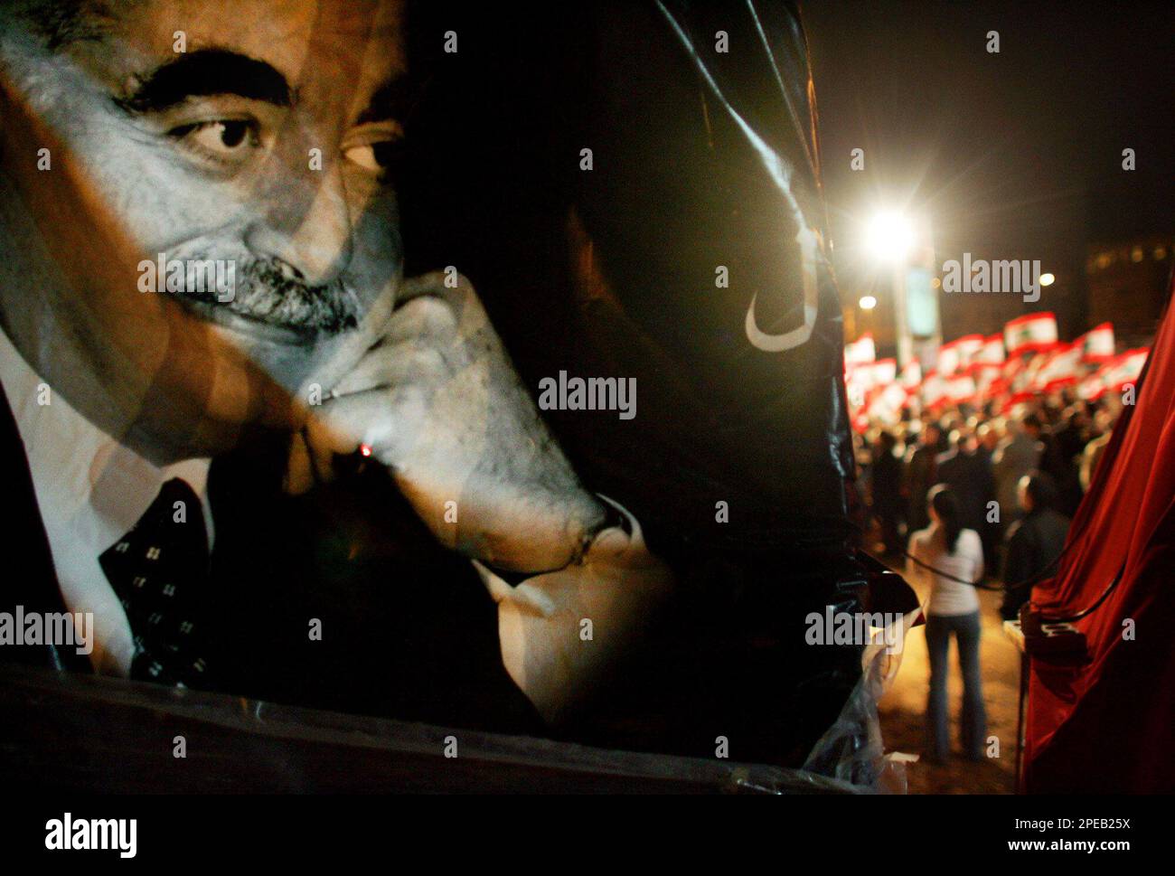 A poster of slain former Lebanese Prime Minister Rafik Hariri is seen as protesters take part in an anti-Syria demonstration in Martyr's Square, central Beirut, Lebanon, Thursday, March 10, 2005. President Emile Lahoud on Thursday reappointed staunchly pro-Syrian Premier Karami to his post and asked him to form the next government, 10 days after Karami had stepped down under popular pressure. Karami immediately called for a national unity government. (AP Photo/Kevin Frayer) Banque D'Images