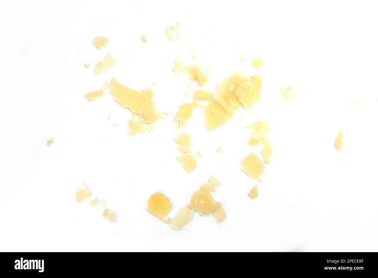 Flocons de fromage parmesan isolés sur fond blanc. Pile de flocons de fromage parmesan et de miettes isolés sur fond blanc. Morceaux carrés d'italien Banque D'Images