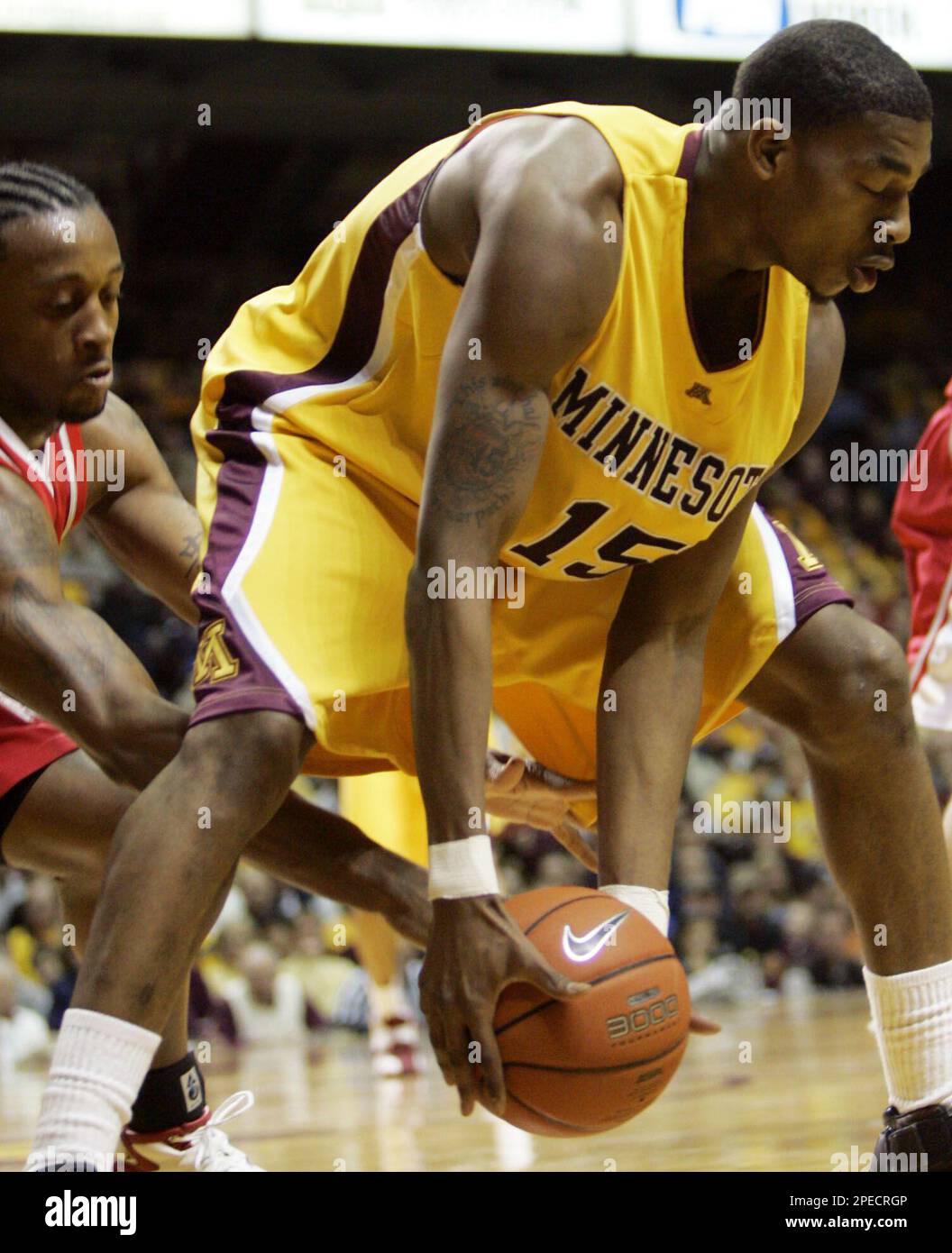 Minnesota guard Vincent Grier (15) scoops up a loose ball as Ohio State guard Je'Kel Foster reaches for it during the second half in Minneapolis, Saturday, Feb. 19, 2005. Grier had a team-high 14 points as Minnesota beat Ohio State 52-50. (AP Photo/Ann Heisenfelt) Banque D'Images