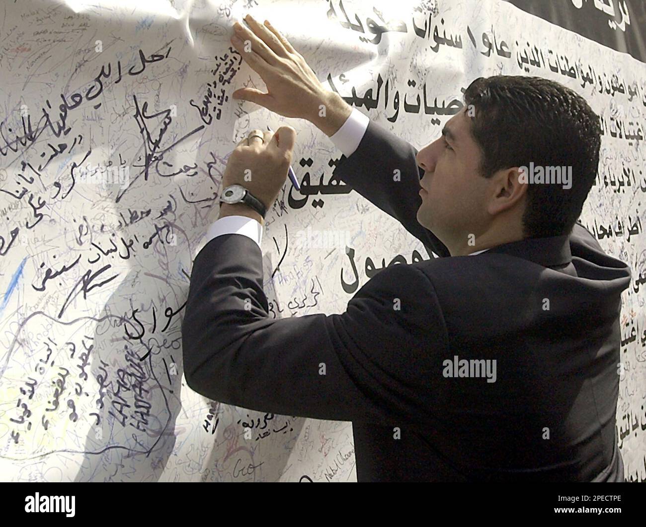 Bahaa Hariri, eldest son of slain Lebanese former Prime Minister Rafik Harir, signs a banner Saturday, Feb. 19, 2005, demanding that the truth about his father's assassination be revealed. He signed the banner after inspecting the bombing scene in central Beirut where Hariri and 16 other people were killed in a massive bombing that targeted the former premier's motorcade on Monday.(AP photo/str) Banque D'Images