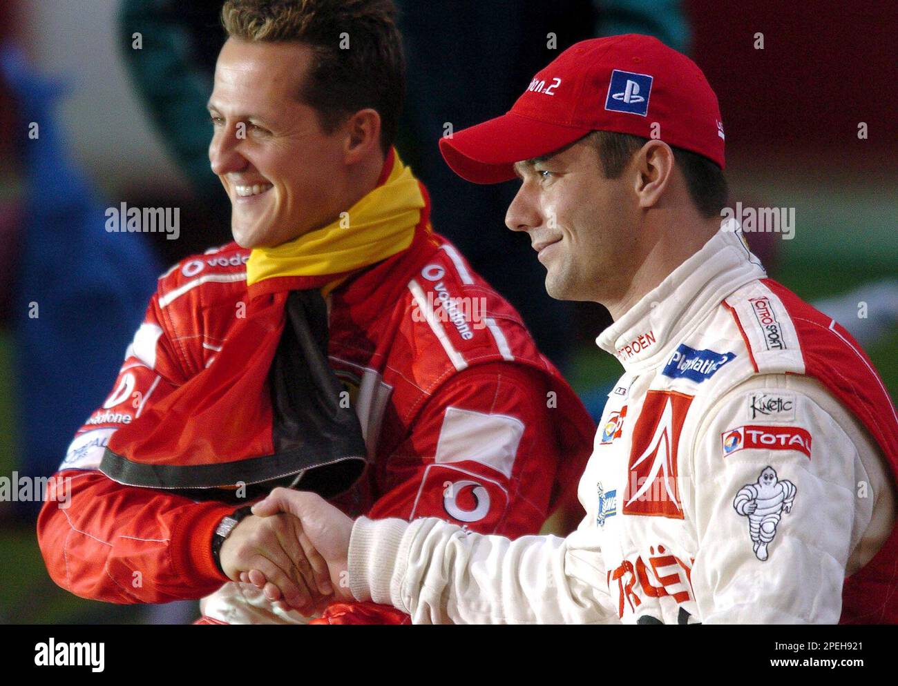 German Formula One champion Michael Schumacher, left, shakes hands with French rally champion Sebastien Loeb during the Race of Champions exhibition at the Stade de France stadium outside Paris, Saturday Dec.4, 2004. The Race of Champions, a yearly event since 1988, featured 16 pilots from various motor racing disciplines, including NASCAR, Champ Car and Indy 500 specialists.(AP Photo/Cedric Joubert) Banque D'Images