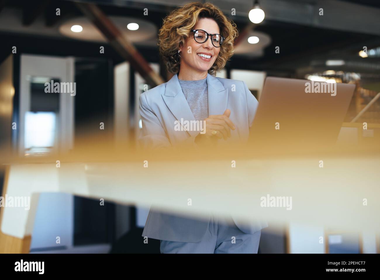 Femme d'affaires caucasienne ayant un appel vidéo dans un bureau de collègue. Femme d'affaires professionnelle ayant une réunion en ligne. Femme professionnelle faisant re Banque D'Images