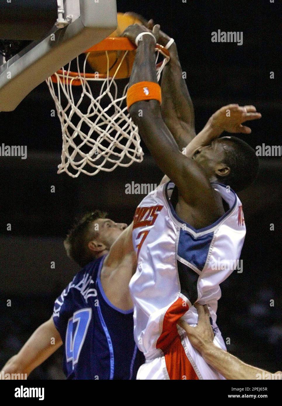 Charlotte Bobcats' Gerald Wallace, right, is fouled by Utah Jazz's Andrei Kirilenko, left, of Russia, as he dunks in the first quarter in Charlotte, N.C., Tuesday, Nov. 16, 2004. (AP Photo/Chuck Burton) Banque D'Images