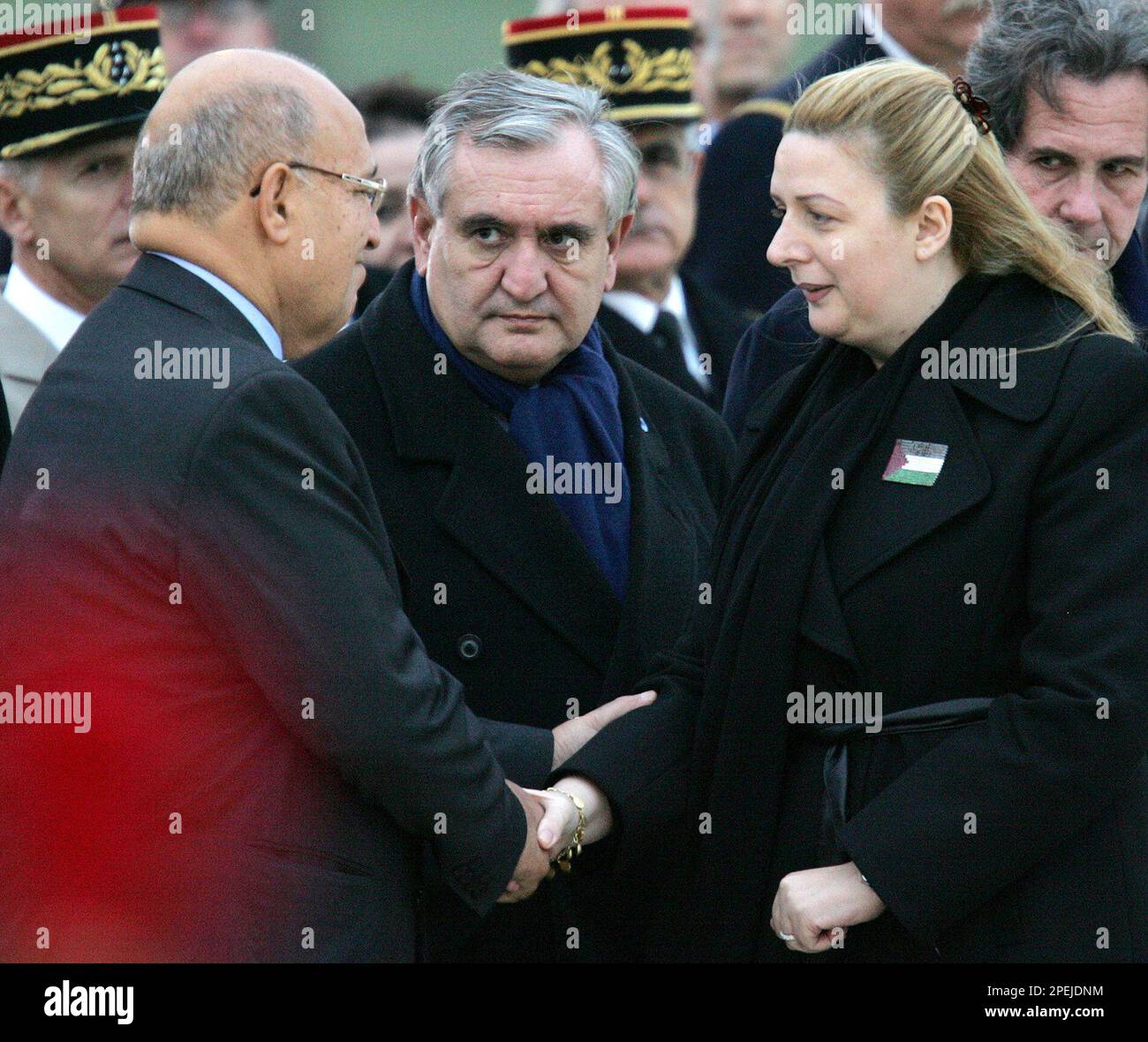 Palestinian Foreign Minister Nabil Shaath, left, shakes hands with Suha Arafat, widow of Palestinian leader Yasser Arafat, at the Villacoublay military base, outside Paris, Thursday, Nov. 11, 2004. Arafat, died early Thursday, he was 75. At center is French Prime Minister Jean-Pierre Raffarin, at right is French National Assembly house speaker Jean-Louis Debre. (AP Photo/Alastair Grant) Banque D'Images