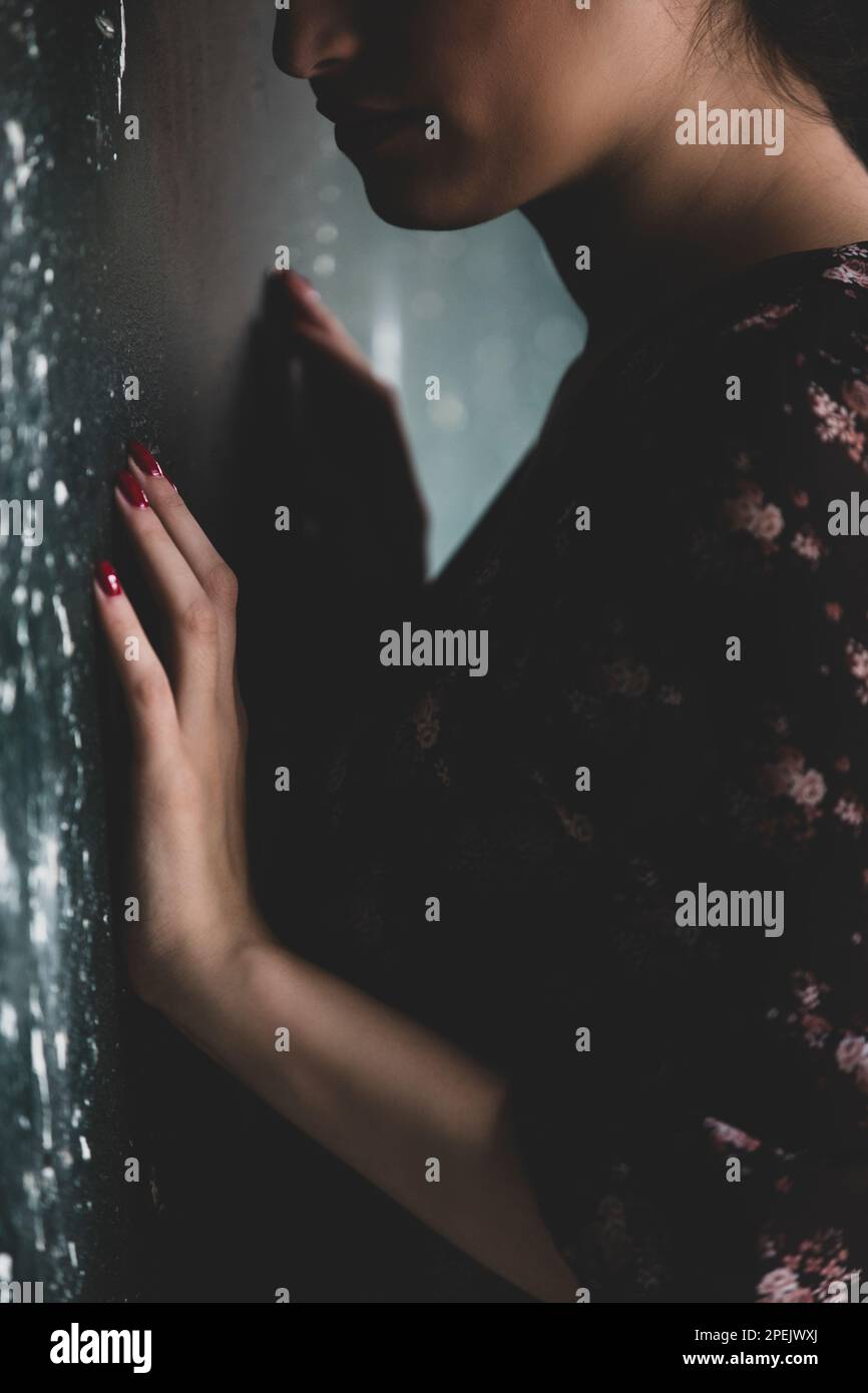 Gros plan de la triste femme penchée contre le mur Banque D'Images