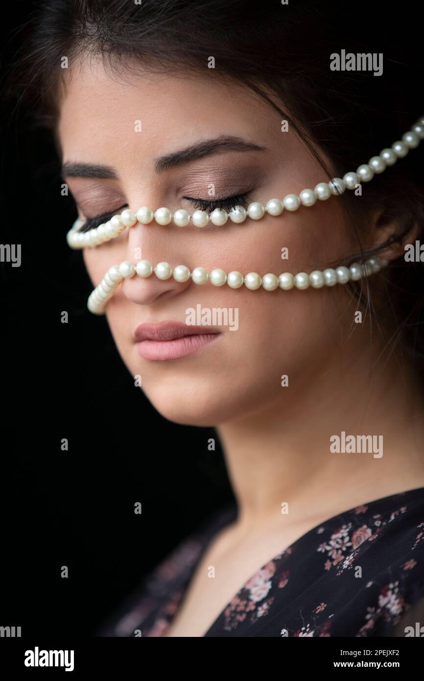 Belle femme yougn yeux fermés avec des perles sur le visage Banque D'Images