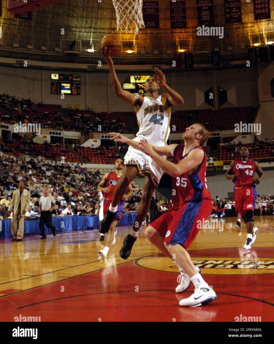 New Orleans Hornets' P.J. Brown (42) goes in for a layup against Los Angeles Clippers' Chris Kaman (35), Saturday, Oct. 16, 2004, at the Cajundome in Lafayette, La. (AP Photo/Brad Kemp) Banque D'Images
