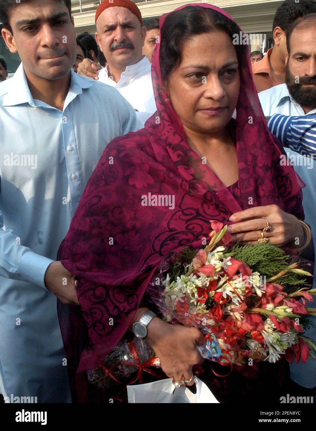 Nusrat Shahbaz, sister-in-law of exiled former Prime Minister Nawaz Sharif, accompanied by her son Hamza Shahbaz, left, arrives at Lahore airport, Pakistan, Saturday, Sept. 18, 2004. Three relatives of Sharif arrived in the eastern city of Lahore on Saturday from Saudi Arabia, to arrange marriages for the two younger women, a family spokesman said. (AP Photo/K. M Chaudhry) Banque D'Images