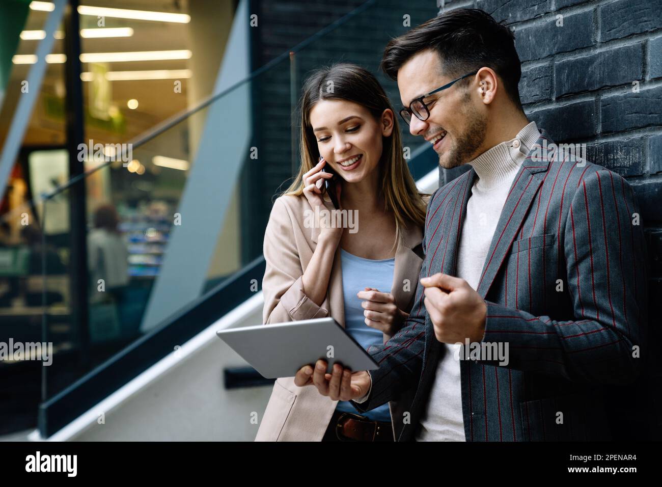 Homme et femme parlant en centre-ville en style d'affaires travaillant ensemble, souriant Banque D'Images