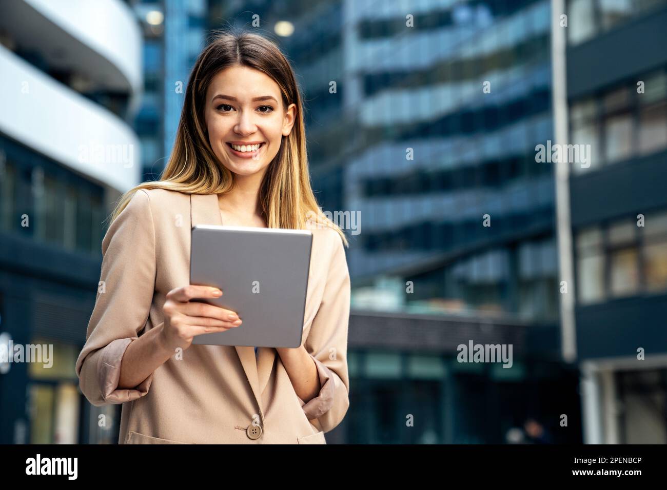 Portrait d'une femme d'affaires prospère utilisant une tablette numérique devant un bâtiment d'affaires moderne Banque D'Images