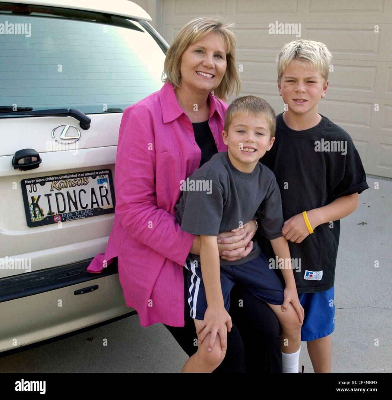 ** ADVANCE FOR WEEKEND EDITIONS, SEPT. 18-19 **Jenette Fennell poses with her children Noah, 5, center, and Alex, 9 at their home in Leawood, Kan. Wednesday, Sept. 15, 2004. Fennell, the president of Kids and Cars, has successfullly lobbied the government to require safer power window switches on cars. (AP Photo/Charlie Riedel) Banque D'Images