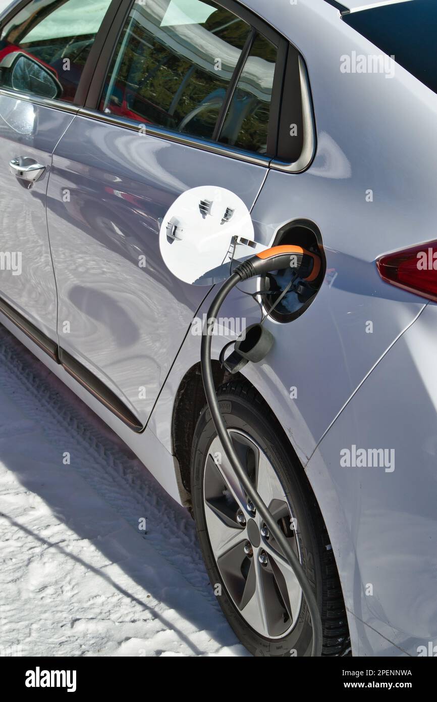 Charger une voiture électrique en hiver à l'extérieur Banque D'Images