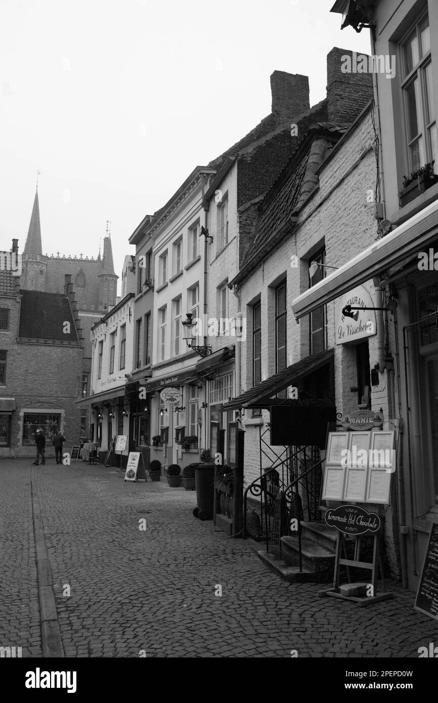 Huidenvettersplein, Brugge, Belgique : restaurants et cafés bordent la petite place magique. Version noir et blanc Banque D'Images