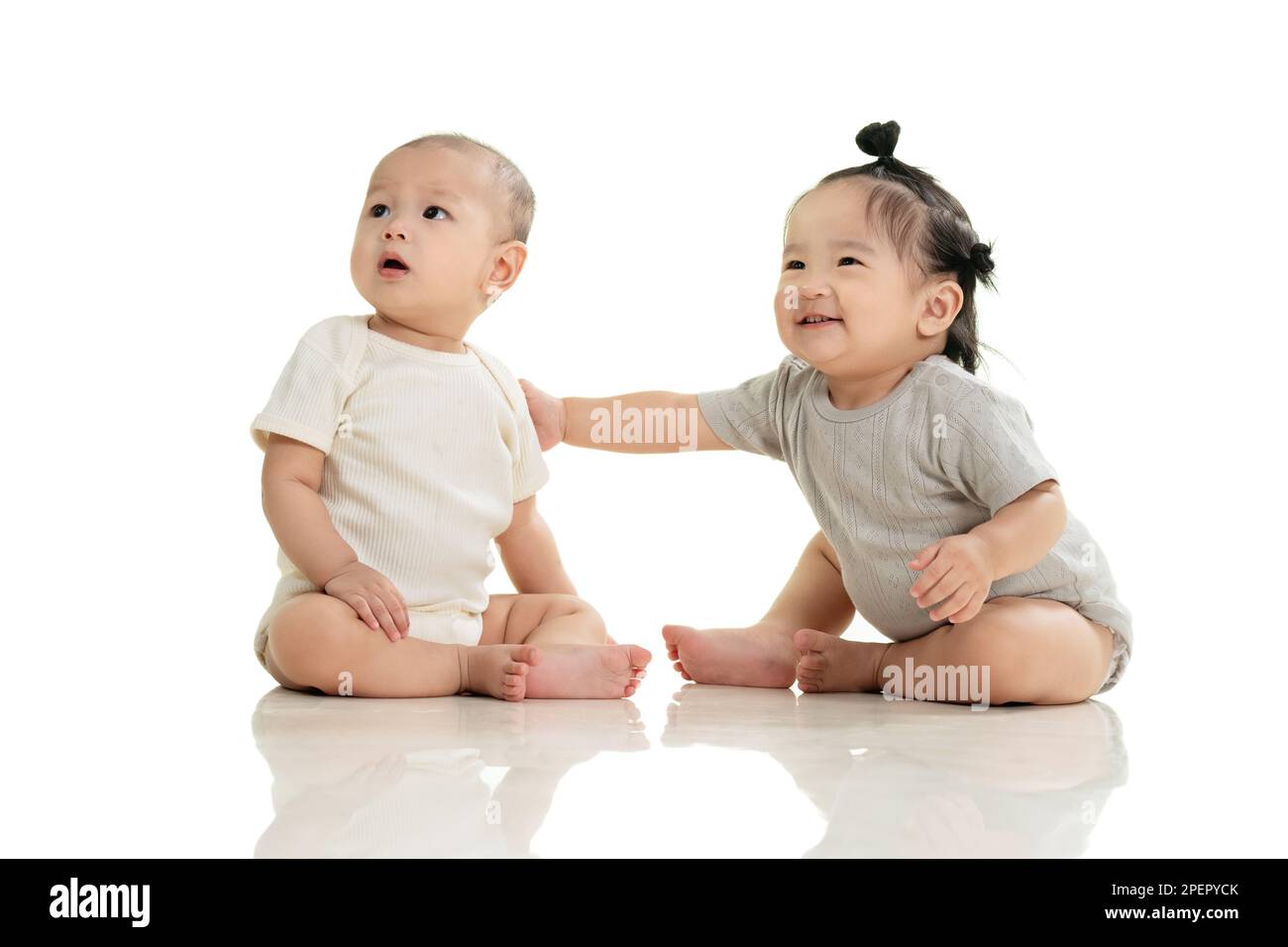 Jouer à deux bébé mignon assis sur le sol Banque D'Images