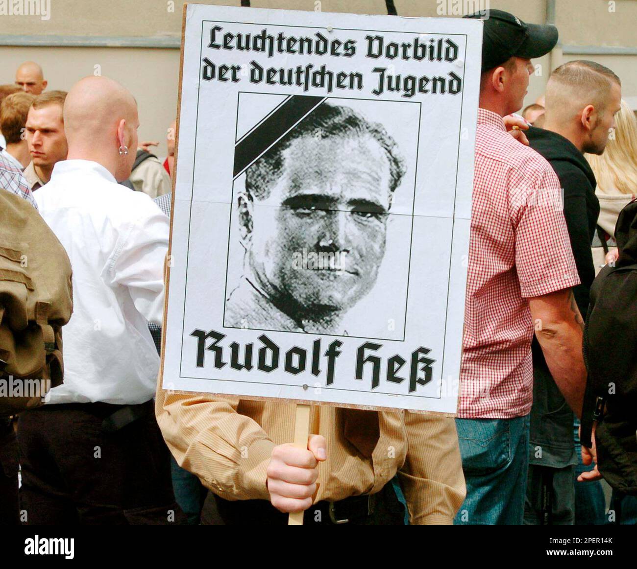 Ein Teilnehmer traegt ein Plakat vor Beginn eines Gedenkmarsches fuer Rudolf Hess am Samstag, 21. August 2004, im bayerischen Wunsiedel, wo der ehemalige Hitler-Stellvertreter begraben ist. Er hatte sich am 17. August 1987 im Kriegsverbrechergefaengnis Berlin-Spandau das Leben genommen und wird seitdem von Rechtsextremen als "Maertyrer" gefeiert. (AP Photo/str) --- A neo-Nazi holda a placard reading ''A shining idol of the German Youth - Rudolf Hess'' as he joins a demonstration prior to the beginning of a commemoration march for Adolf Hitler's deputy Rudolf Hess in the northeastern Bavarian t Banque D'Images