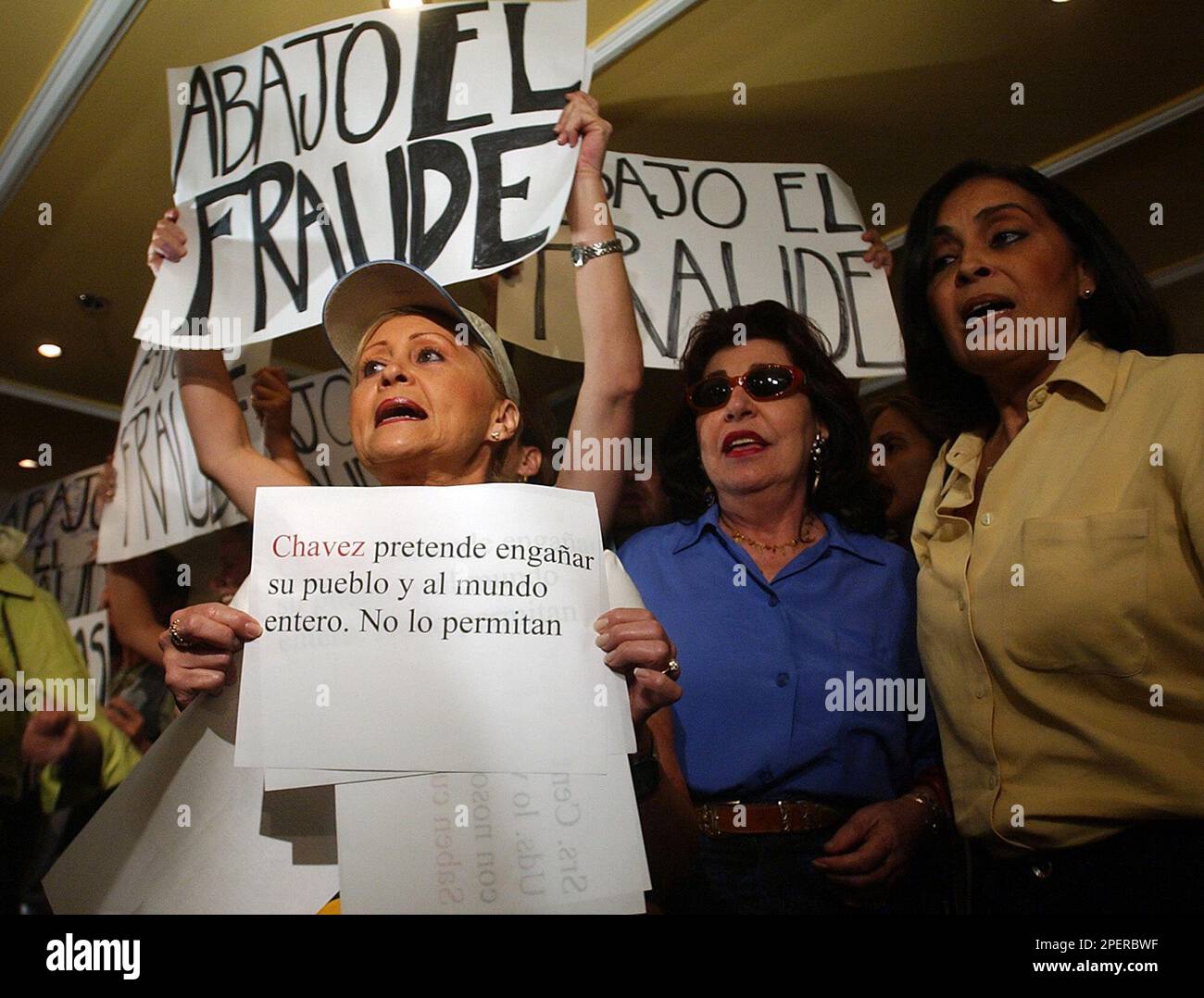 Women protest at a hotel where former U.S. President Jimmy Carter was supposed to give a news conerence in Caracas, Venezuela Monday Aug. 16, 2004 over the victory of Venezuelan President Hugo Chavez in last Aug. 15th recall referendum against his rule. Signs say "Down with the fraud and "Chavez pretends to fool his people and the entire world, dont allow it".(AP Photo/Dario Lopez-Mills) Banque D'Images