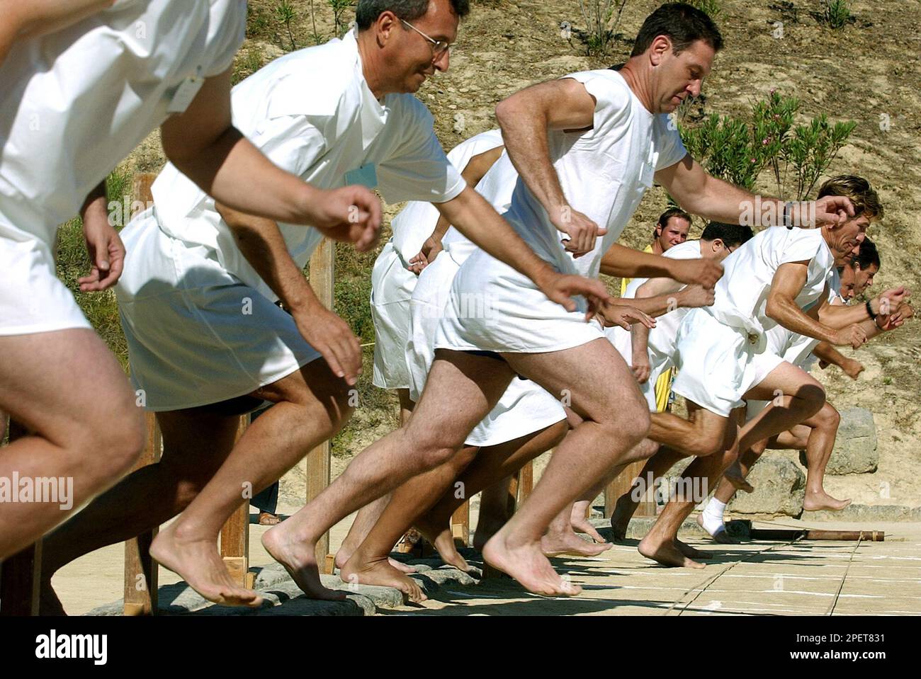 Barefoot runners wearing tunics take part in a footrace in the ancient ...