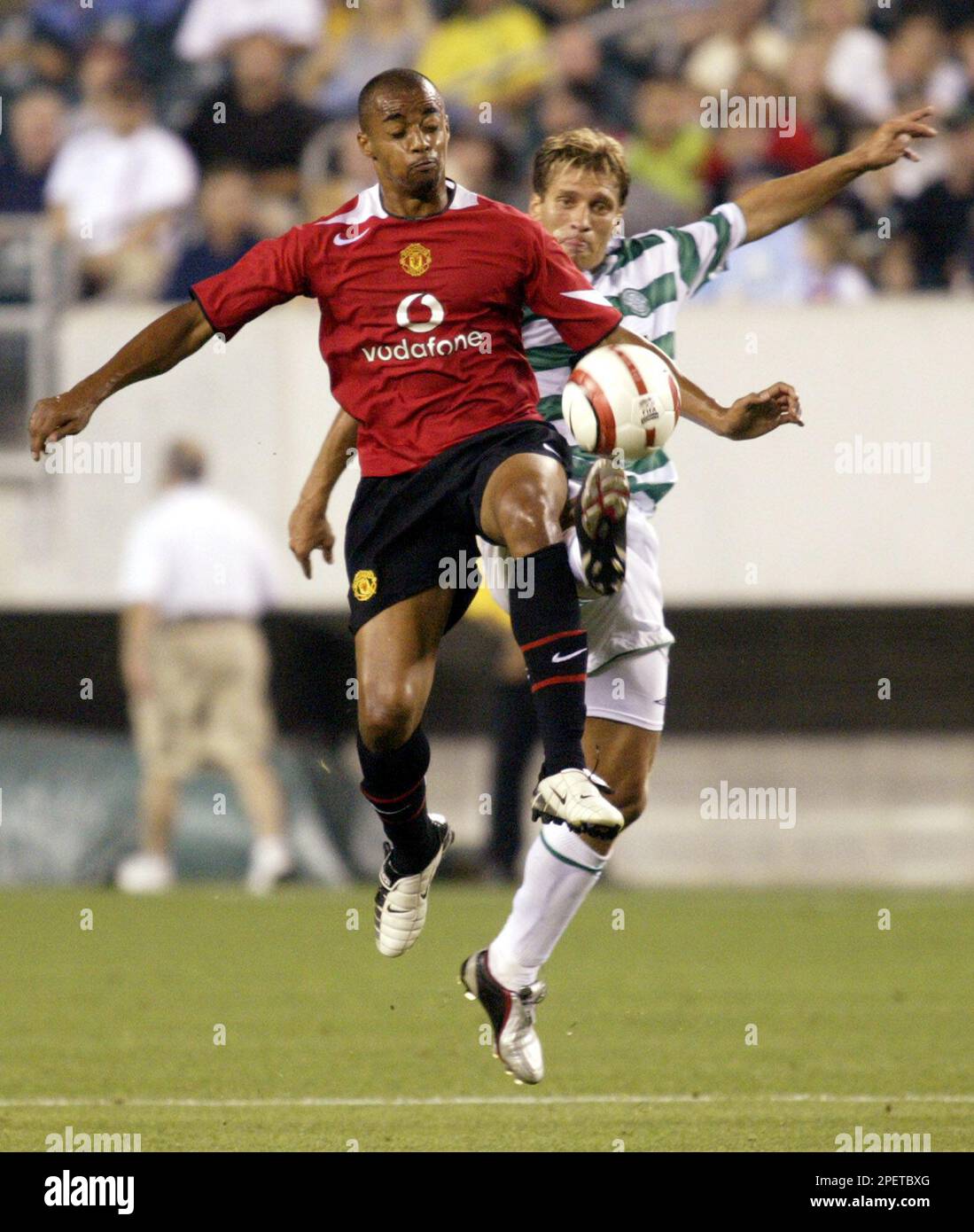 Manchester United's David Bellion, left, and Glasgow Celtic's Stilian Petrov fight for control of the ball during the first half of a exhibition game Wednesday, July 28, 2004. (AP Photo/H. Rumph, Jr.) Banque D'Images