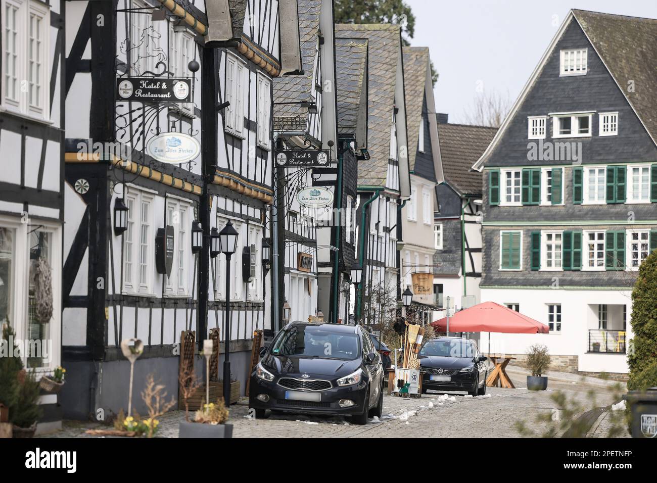 Freudenberg, Allemagne. 16th mars 2023. Des maisons à colombages et des voitures sont visibles dans la vieille ville. À l'école de Luise, une jeune fille de 12 ans tuée dans le sud de la Rhénanie-du-Nord-Westphalie, les élèves doivent être à nouveau progressivement enseignés selon le calendrier après de longues discussions. Luise avait été tué avec de nombreuses blessures au couteau sur 11 mars 2023. Credit: Oliver Berg/dpa - ATTENTION: Plaque(s) d'immatriculation ont été pixélisées pour des raisons juridiques/dpa/Alay Live News Banque D'Images