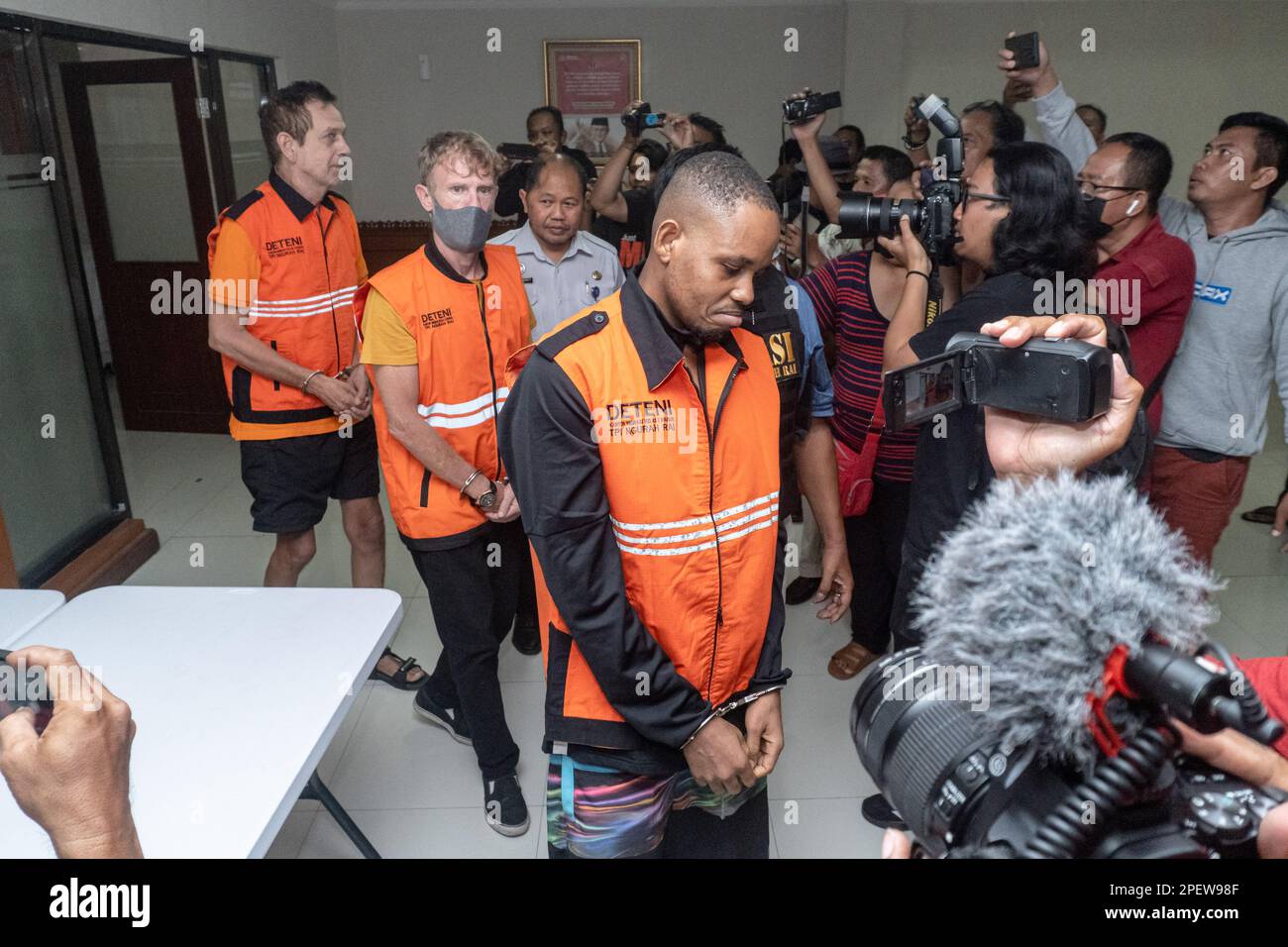 Les étrangers détenus marchent parmi les médias en direction de la conférence de presse. Les autorités de Bali ont expulsé deux ressortissants britanniques et deux ressortissants nigérians pour surséjour. Le gouverneur de Bali, I Wayan Koster, a annoncé dimanche, 12 mars 2023, Que la politique de visa à l'arrivée (VoA) pour les ressortissants ukrainiens et russes sera révoquée afin de réduire les violations du tourisme, qui sont principalement commises par ces deux nationalités. En 2022, la province de Bali a expulsé 194 étrangers, la majorité pour séjour excessif et travail illégal. Banque D'Images