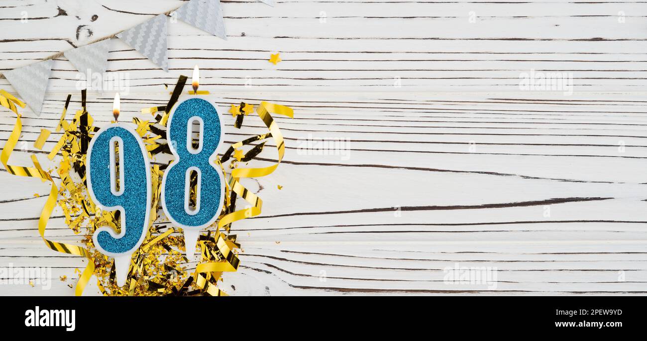 Bougie de célébration bleue numéro 98 sur fond blanc en bois. Joyeux anniversaire bougies. Concept de célébration d'anniversaire, anniversaire, date importante Banque D'Images