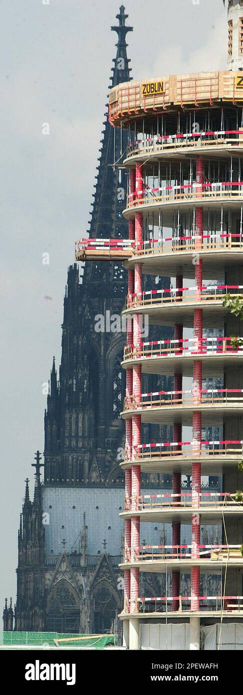 A view onto the Cologne Cathedral, left, which is partially obscured by a tower block shell in Cologne, western Germany, Tuesday, July 6, 2004. The cathedral, previously put on the list of the world cultural heritages by the UN organization UNESCO, has now been added to the UNECSO's Red List of endangered monuments, because the towerbuilding and two other planed other towers could obscure the view of the famous cathedral. (AP Photo/Hermann J. Knippertz) Banque D'Images