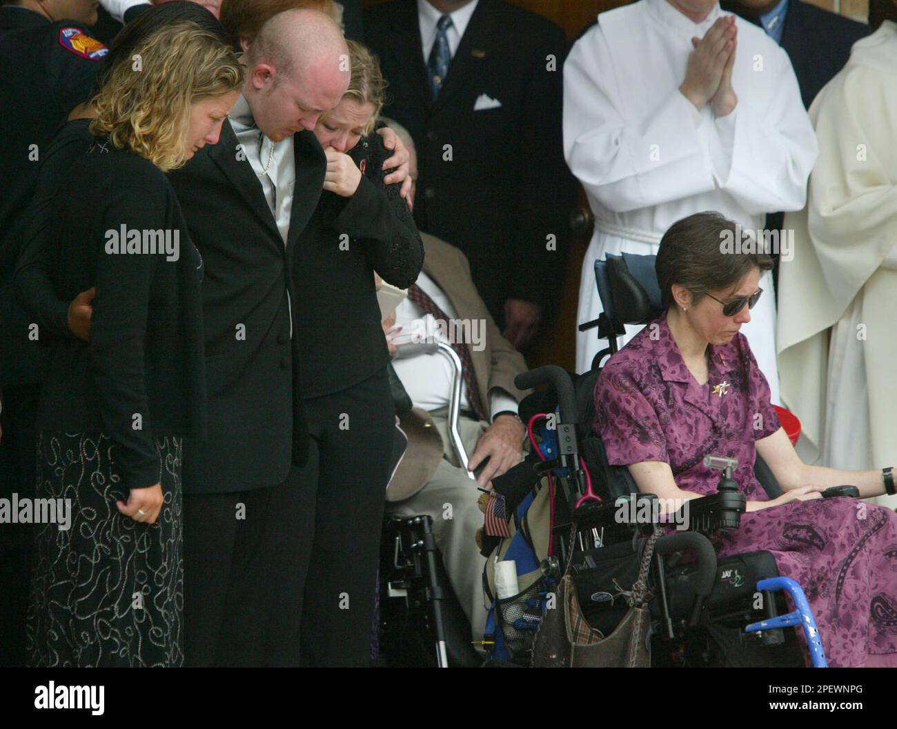 Friends and family members gather outside the St. Catherine Laboure Catholic Church Monday, June 28, 2004, in Wheaton, Md., along with mother Jeni Stepanek, right, after the funeral ceremony of poet Mattie Stepanek. Mattie was about a month shy of his 14th birthday when he died Tuesday, June 22, 2004, of complications from muscular dystrophy. He became a best-selling author who published five volumes of verse. (AP Photo/ Matt Houston) Banque D'Images