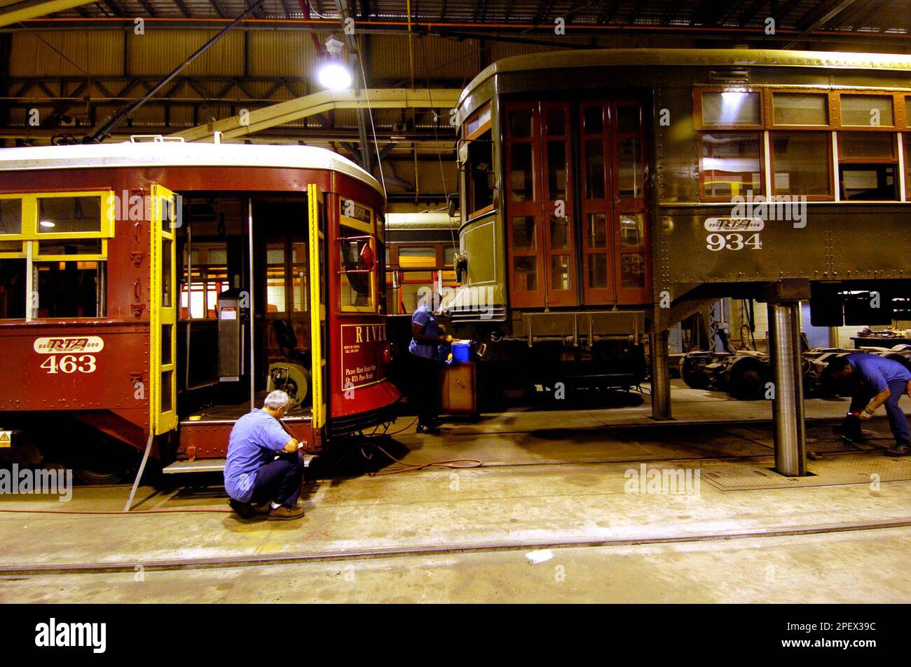 **ADVANCE FOR WEEKEND EDITIONS JUNE 26-27**FILE**Regional Transit employees work on a new streetcar, left, and an older 1920s model, right, at the Carrollton Station in New Orleans Tuesday, May 18, 2004. The 1920s cars that clatter along St. Charles Avenue are not air-conditioned, the windows open to allow a breeze, breaks squeal and the wheels rattle nosily on the tracks. The new cars are air-conditioned, much quieter, with better suspension and a smoother ride. (AP Photo/Bill Haber) Banque D'Images