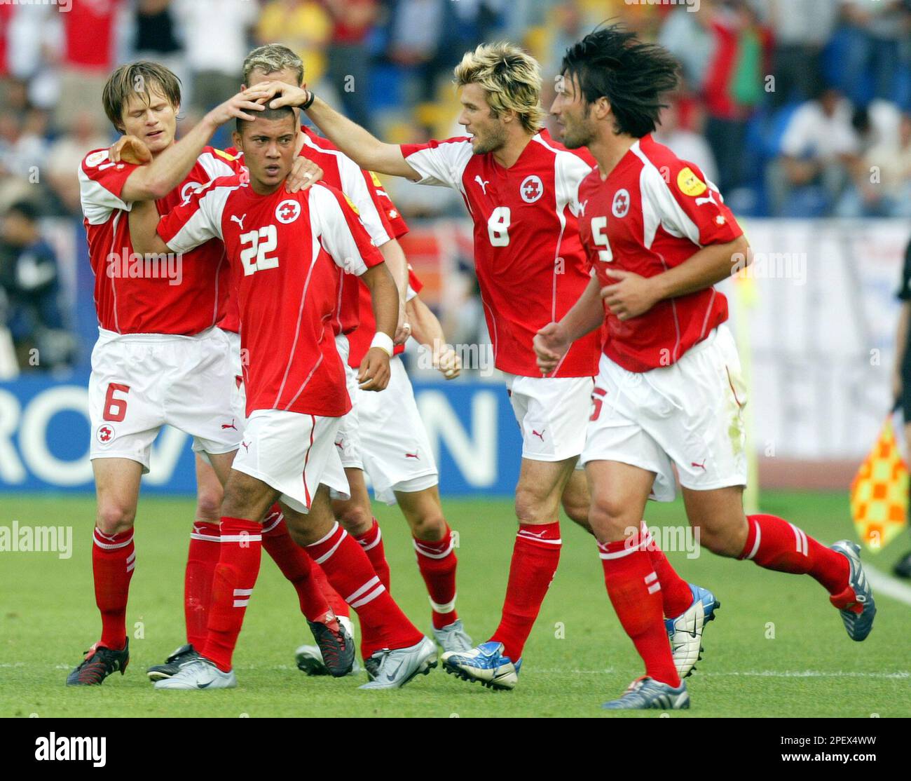Switzerland's Johann Vonlanthen (22) is congralulated by teammates Johann Vogel (6), Raphael Wicky (8) and Murat Yakin (5) after scoring against France during their Group B Euro 2004 first round match at the Cidade de Coimbra Stadium, in Coimbra, Portugal, Monday, June 21 2004. England and Croatia also play in Group B. (AP Photo/Murad Sezer) ** FOR EDITORIAL USE ONLY NO WIRELESS COMMERCIAL OR PROMOTIONAL LICENSING PERMITTED ** Banque D'Images