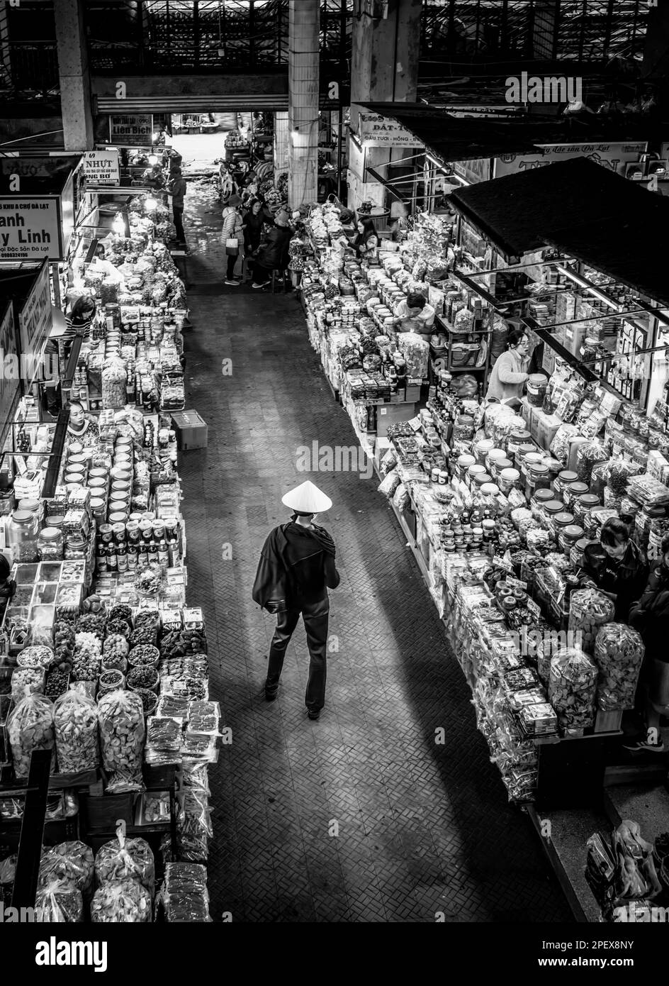 Un touriste étranger portant un chapeau conique vietnamien visite le marché Dalat dans le centre du Vietnam. Banque D'Images