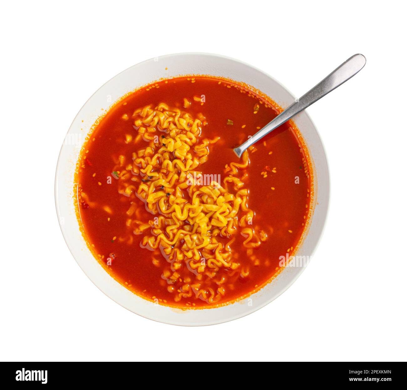 Soupe de nouilles épicées rouges dans un bol blanc vue isolée sur le dessus, gros plan de texture ramen au piment fort, cuisine coréenne épicée Banque D'Images