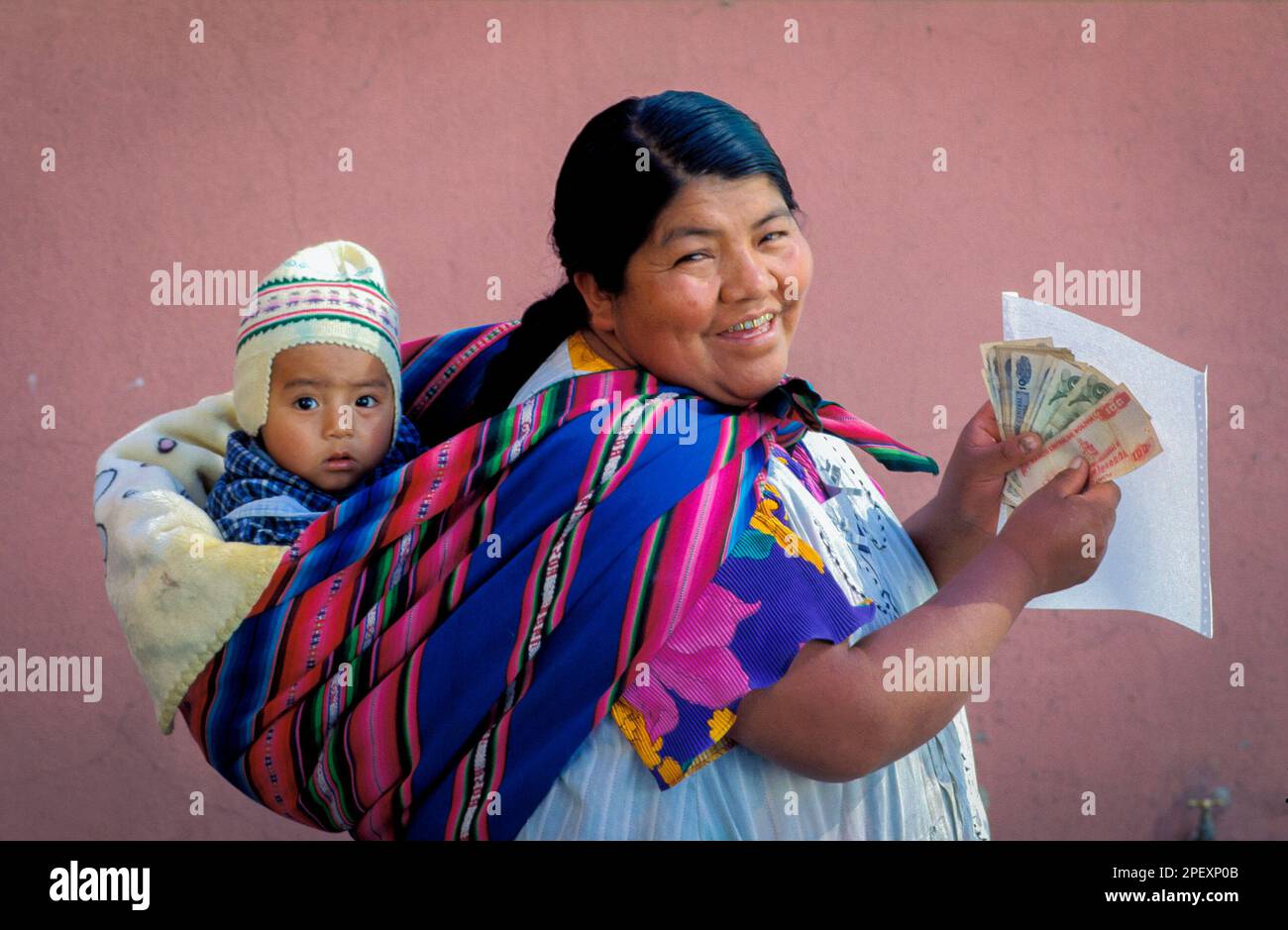 Bolivie, la Paz. Mère avec bébé vient de recevoir de l'argent de la société financière. Banque D'Images