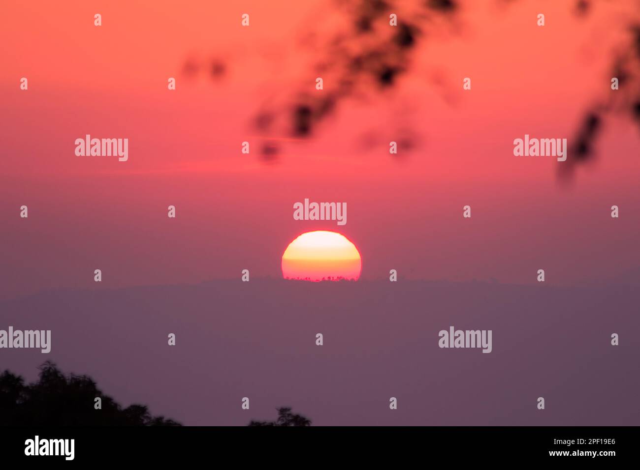 Le paysage du soleil levant brille orange à travers le ciel. Banque D'Images