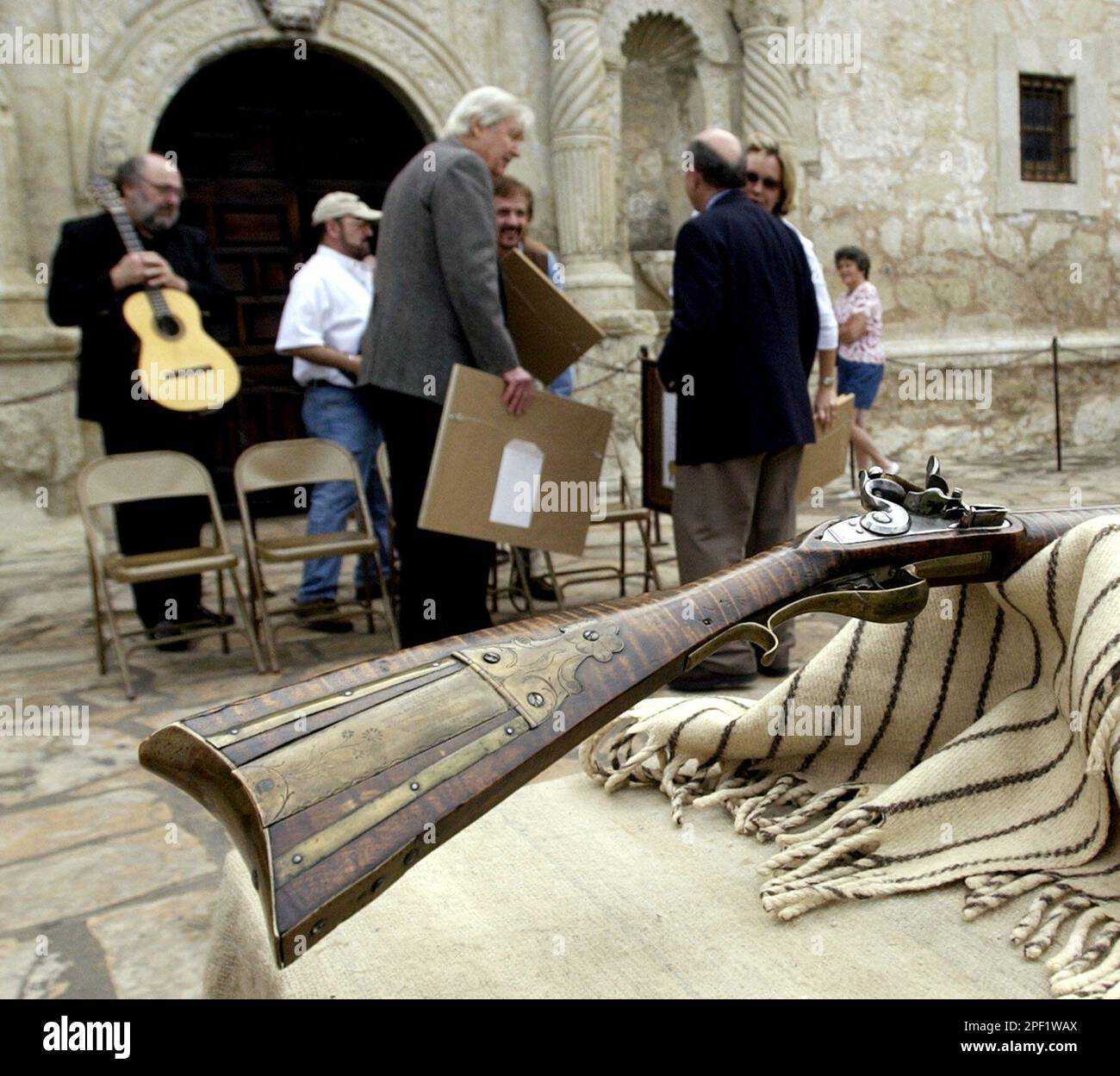 Fess Parker, who gained fame for his portrayal of Davy Crockett in the 1950s Walt Disney TV series, center, visits with Alamo director David Roberts, right, after he presented a 180-year-old Kentucky long rifle to the Alamo for its collection at the Alamo in San Antonio, Friday, March 5, 2004. (AP Photo/Eric Gay) Banque D'Images