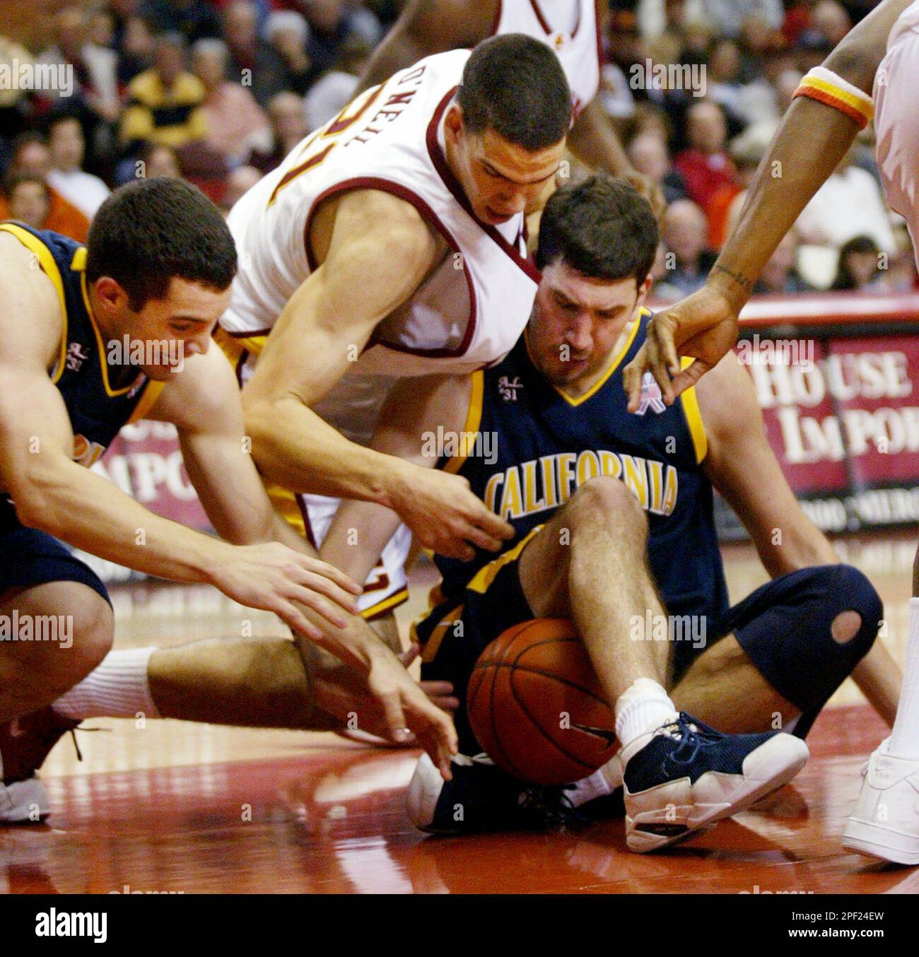 California's Richard Midgley, left, and Amit Tamir, right, scramble for a loose ball with Southern California's Rory O'Neil, center, during the first half in Los Angeles on Saturday, Feb. 21, 2004. (AP Photo/Francis Specker) Banque D'Images