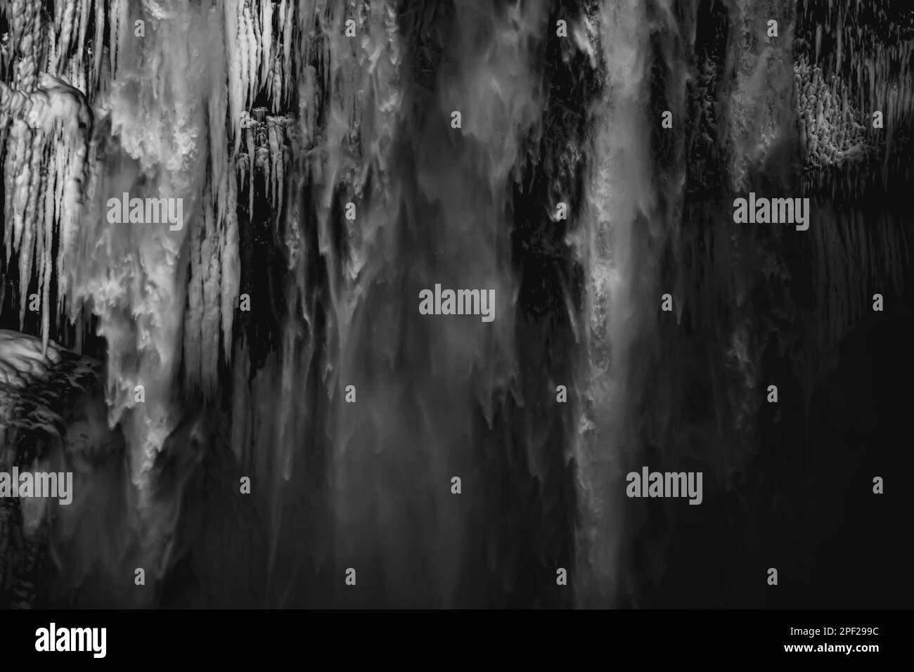 Détail des stalagmites et de l'eau tombant de la cascade de Skógafoss en Islande illuminée par la lumière du soleil en fin d'après-midi créant une atmosphère païnelle Banque D'Images