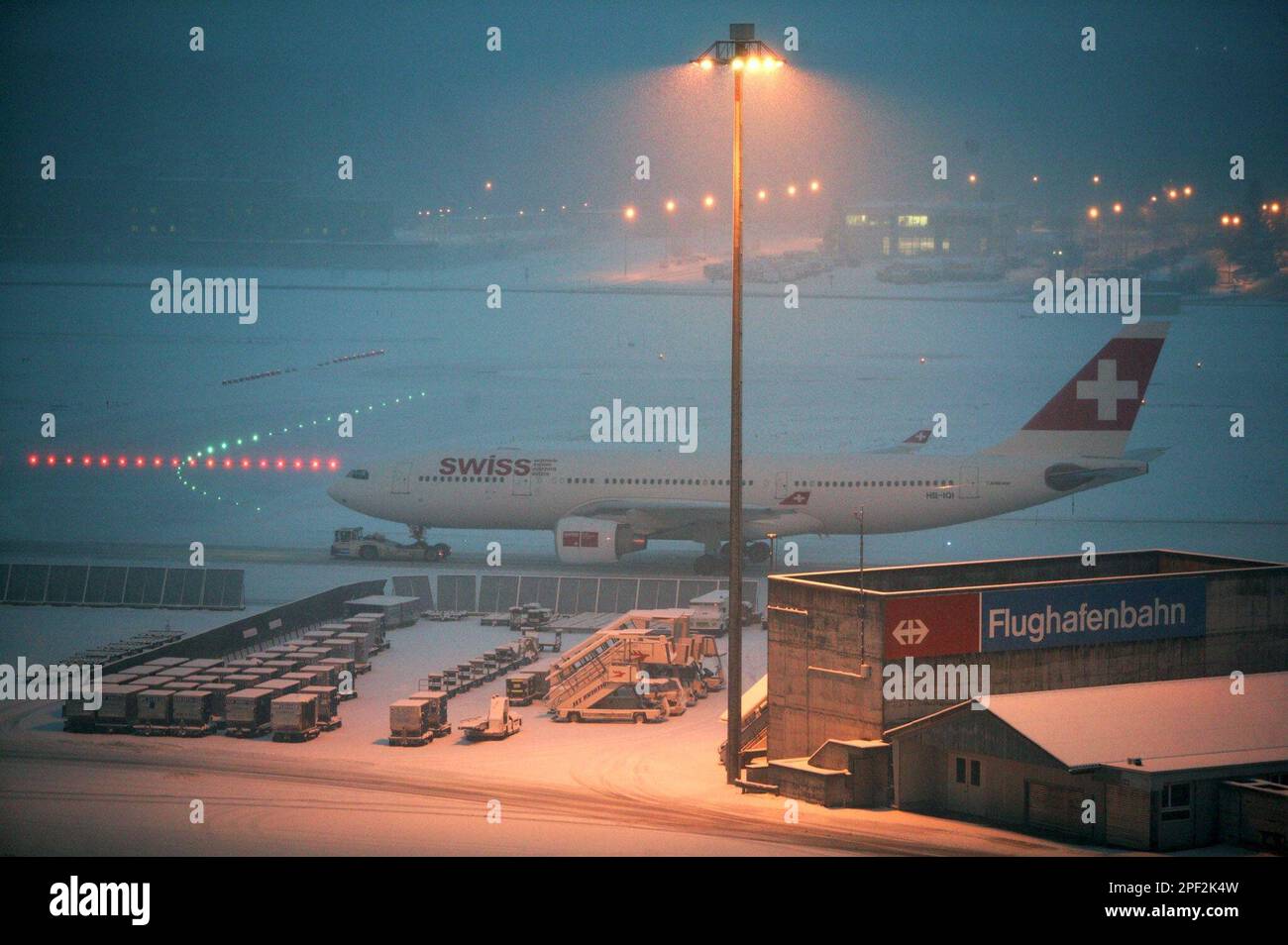 A snow covered plane of the Swiss International airlines stands on the tarmac of the Zurich, Switzerland, Kloten airport, Tuesday morning, Jan. 27, 2004. Continuing snowfall caused traffic jams on the ground and in the air. (AP Photo/Keystone, Martin Ruetschi) Banque D'Images