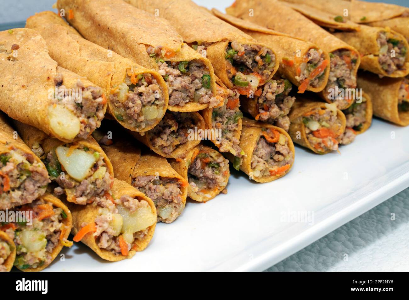 Flautas de bœuf et de légumes mexicains en gros plan. Flatas sont également connus sous le nom de taquitos, tacos dorados ou tacos roulés Banque D'Images