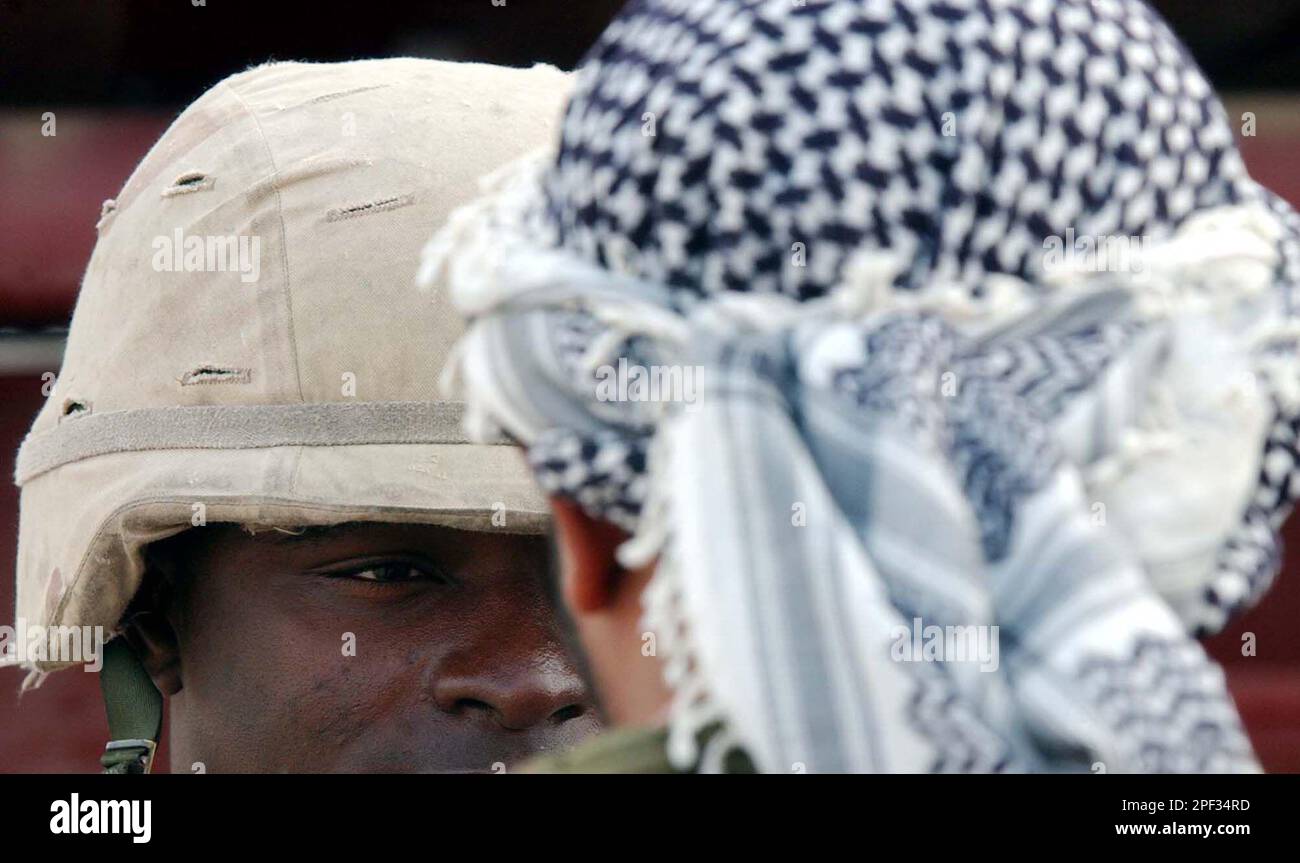 U.S. Army Spc. Tyron Bohannon from Arkansas, of 1st Battalion, 22nd Regiment, (1-22) of the 4th Infantry Division, talks to an Iraqi man in Tikrit, Iraq, Sunday, Dec. 28, 2003. A roadside bomb killed a U.S. soldier and two children in Baghdad on Sunday, a day after a coordinated guerrilla onslaught in the southern city of Karbala left 13 dead and almost 200 injured. (AP Photo/Gregorio Borgia) Banque D'Images
