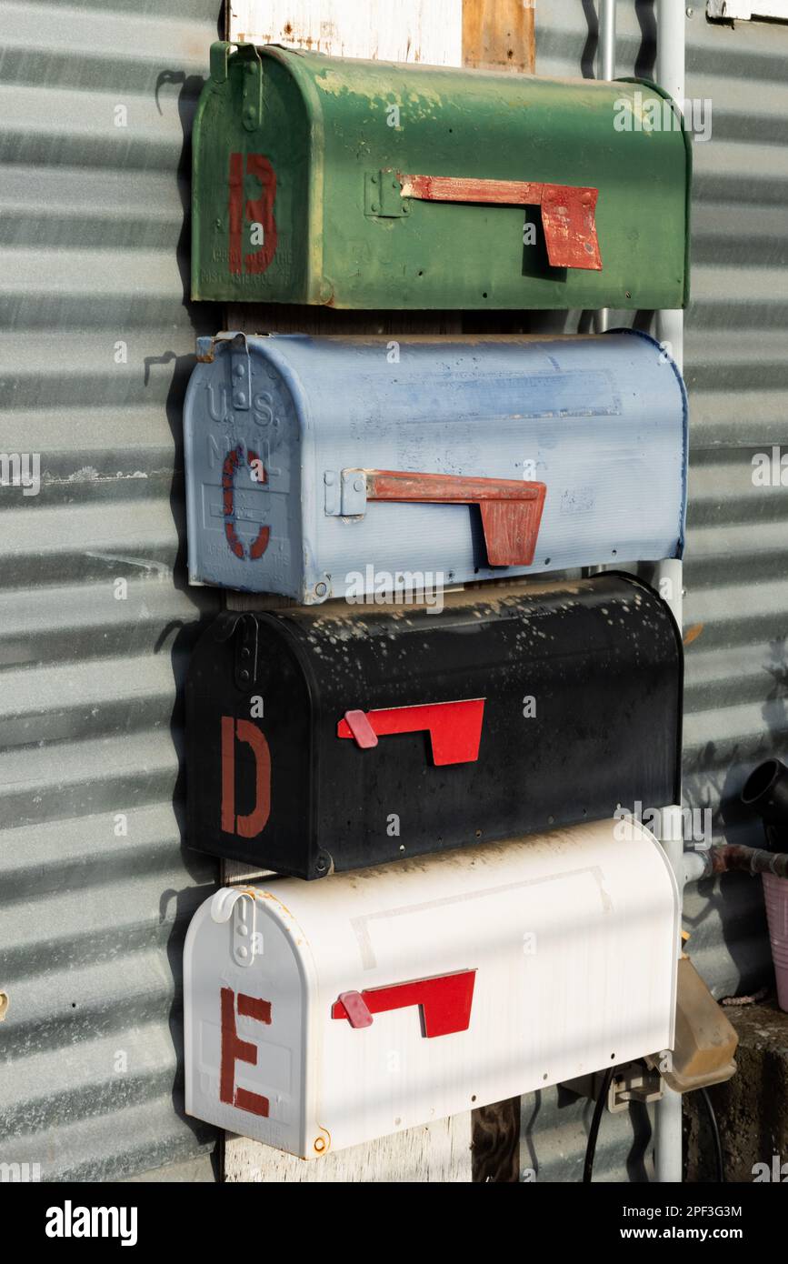 Rangées de boîtes aux lettres en métal, à dessus rond, peintes en couleur. Banque D'Images